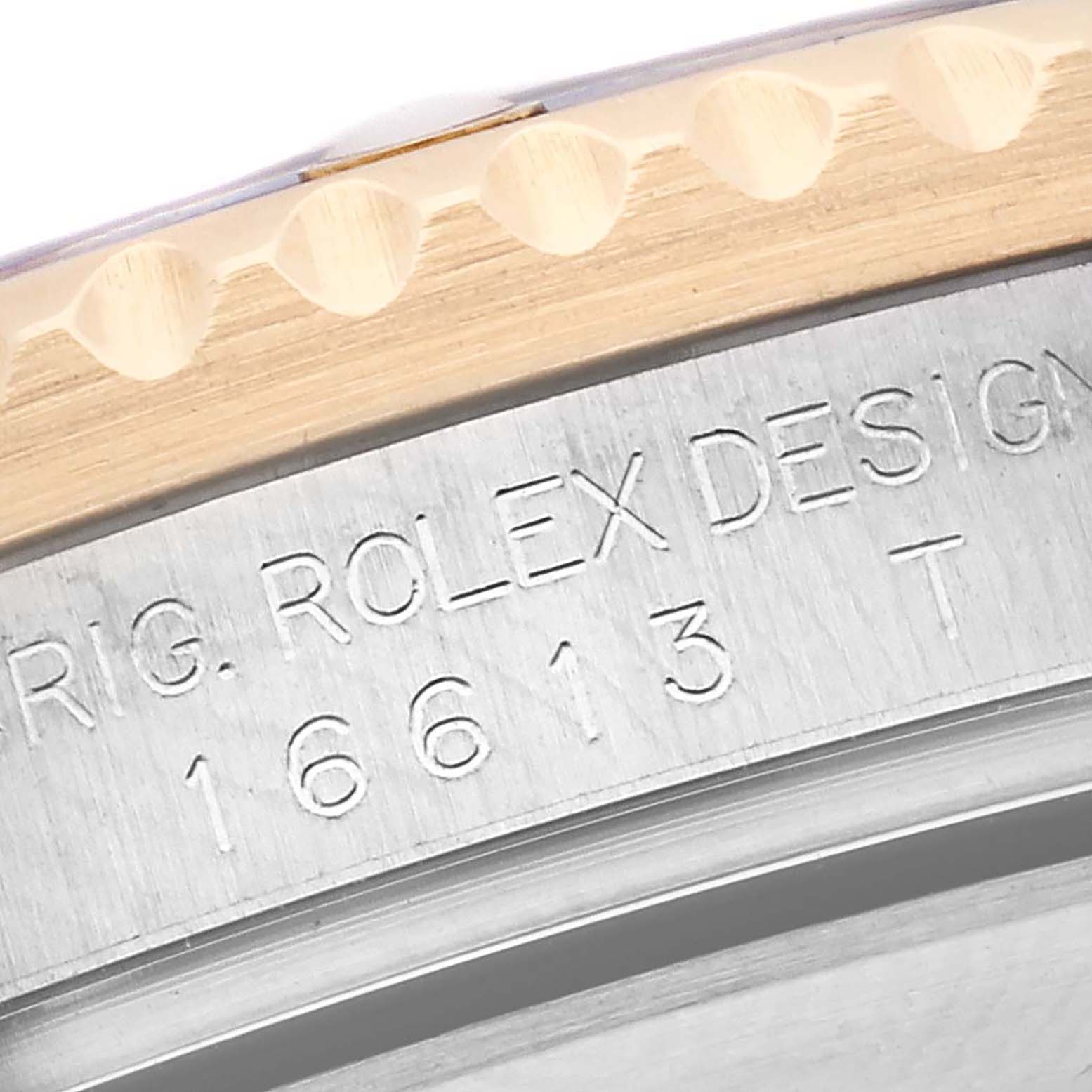 The image shows an angled close-up of the bezel and engraved side of the case back of a Rolex Submariner 16613 Men
s Steel and Gold (two tone) Blue Dial 16613 Men
s Steel and Gold (two tone) Blue Dial model 16613.