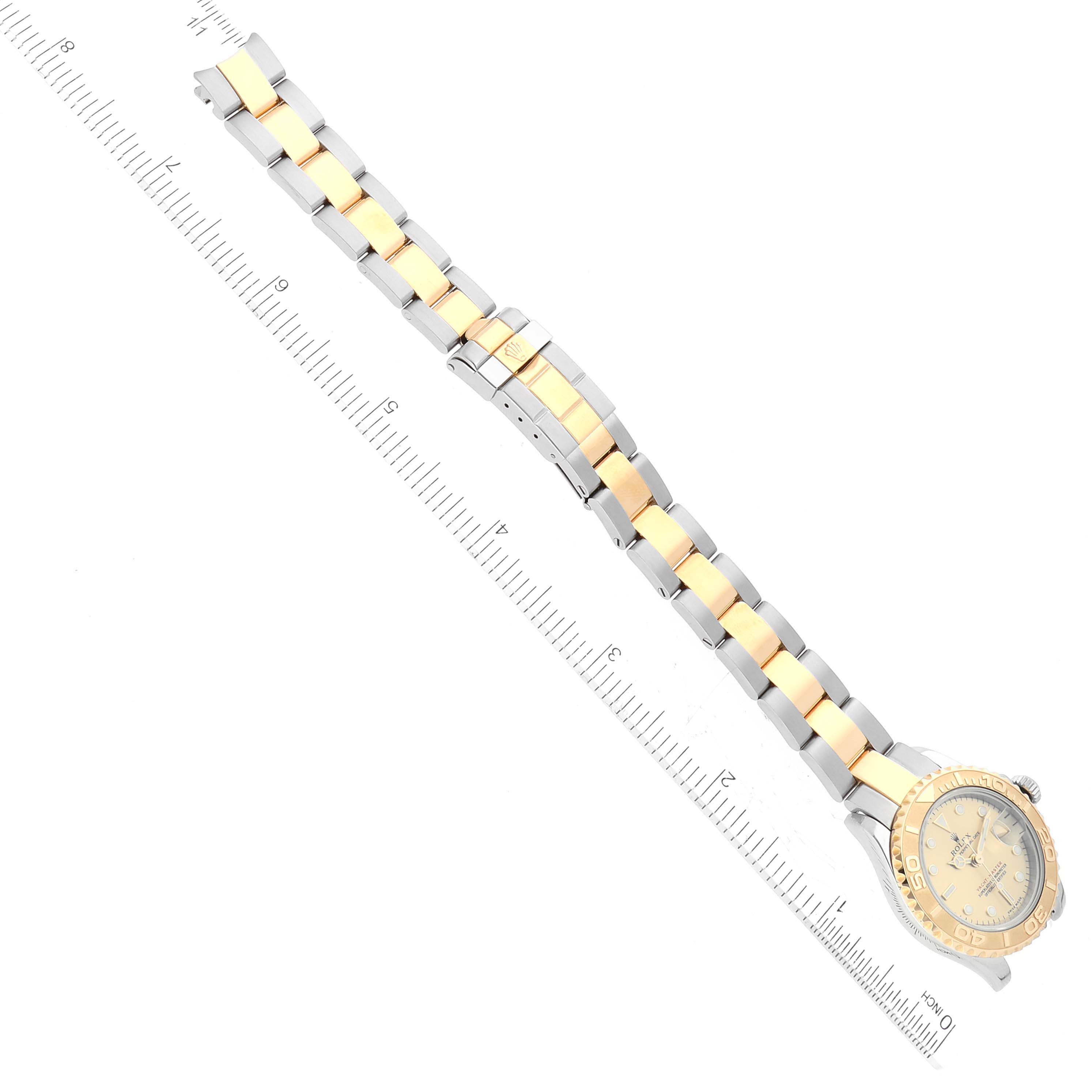 The Rolex Yacht-Master 169623 Women's Steel and Gold (two tone) Champagne Dial 169623 Women's Steel and Gold (two tone) Champagne Dial watch is shown from a top-down angle, featuring its full bracelet and dial alongside a measuring ruler.