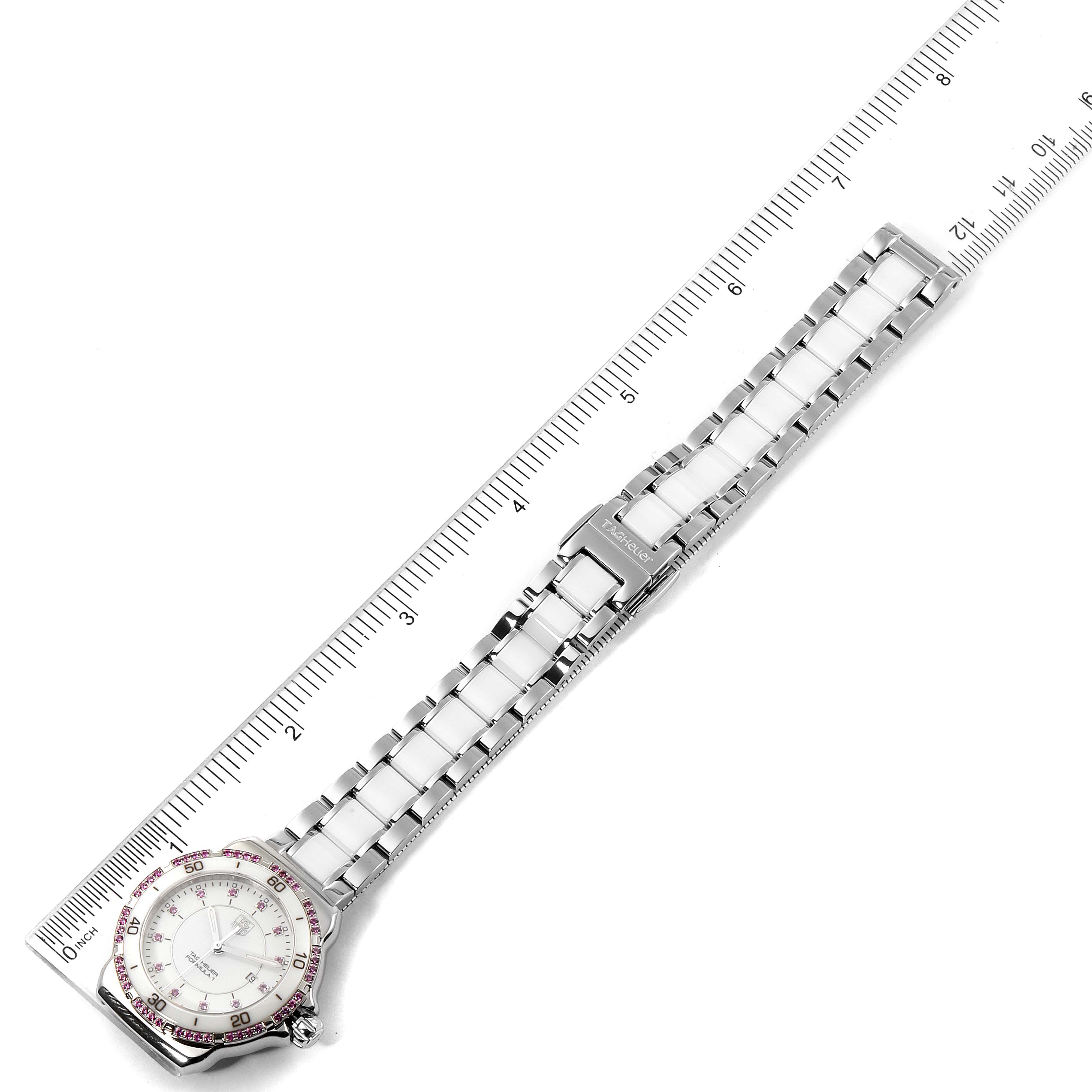 The image shows a top view of a Tag Heuer Formula 1 WAH1319.BA0868 Women's Stainless Steel White Dial WAH1319.BA0868 Women's Stainless Steel White Dial watch with its full metal strap and a measuring ruler nearby.