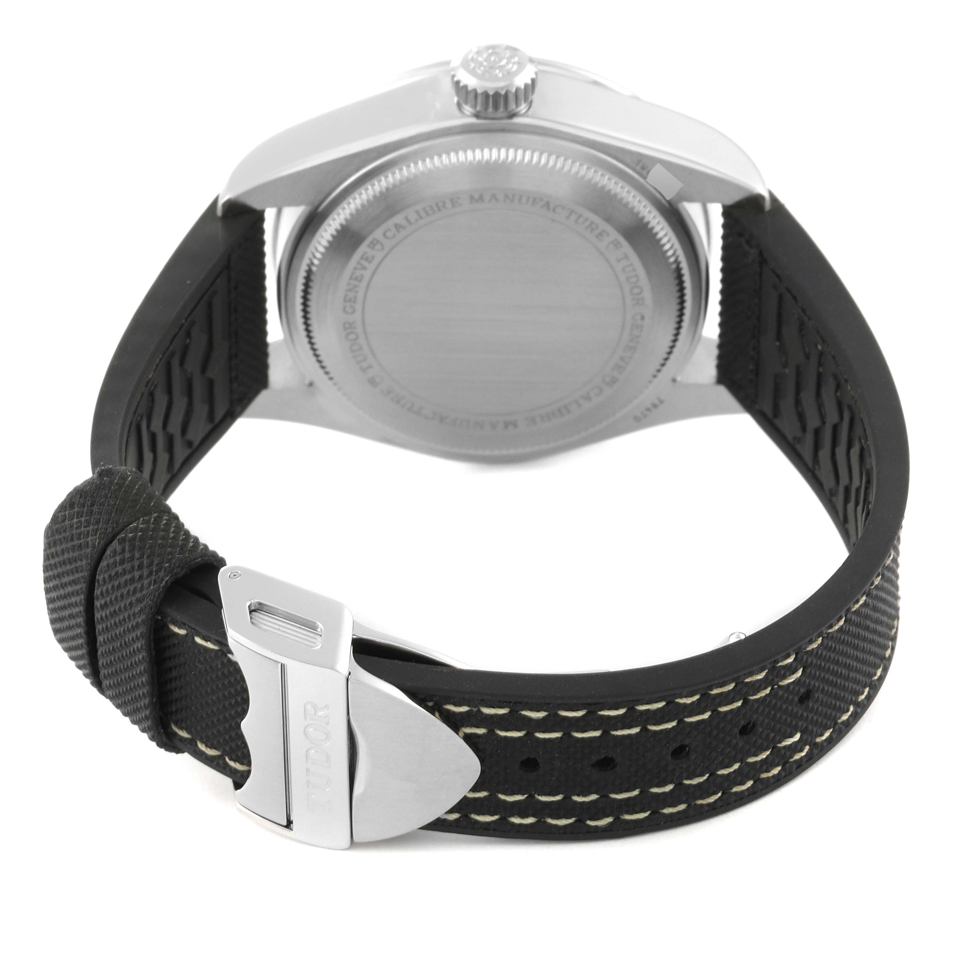 The photo shows the backside of a Tudor Heritage Black Bay M79470 Men
s Stainless Steel Black Dial M79470 Men
s Stainless Steel Black Dial watch, highlighting the case back and rubber strap with buckle.