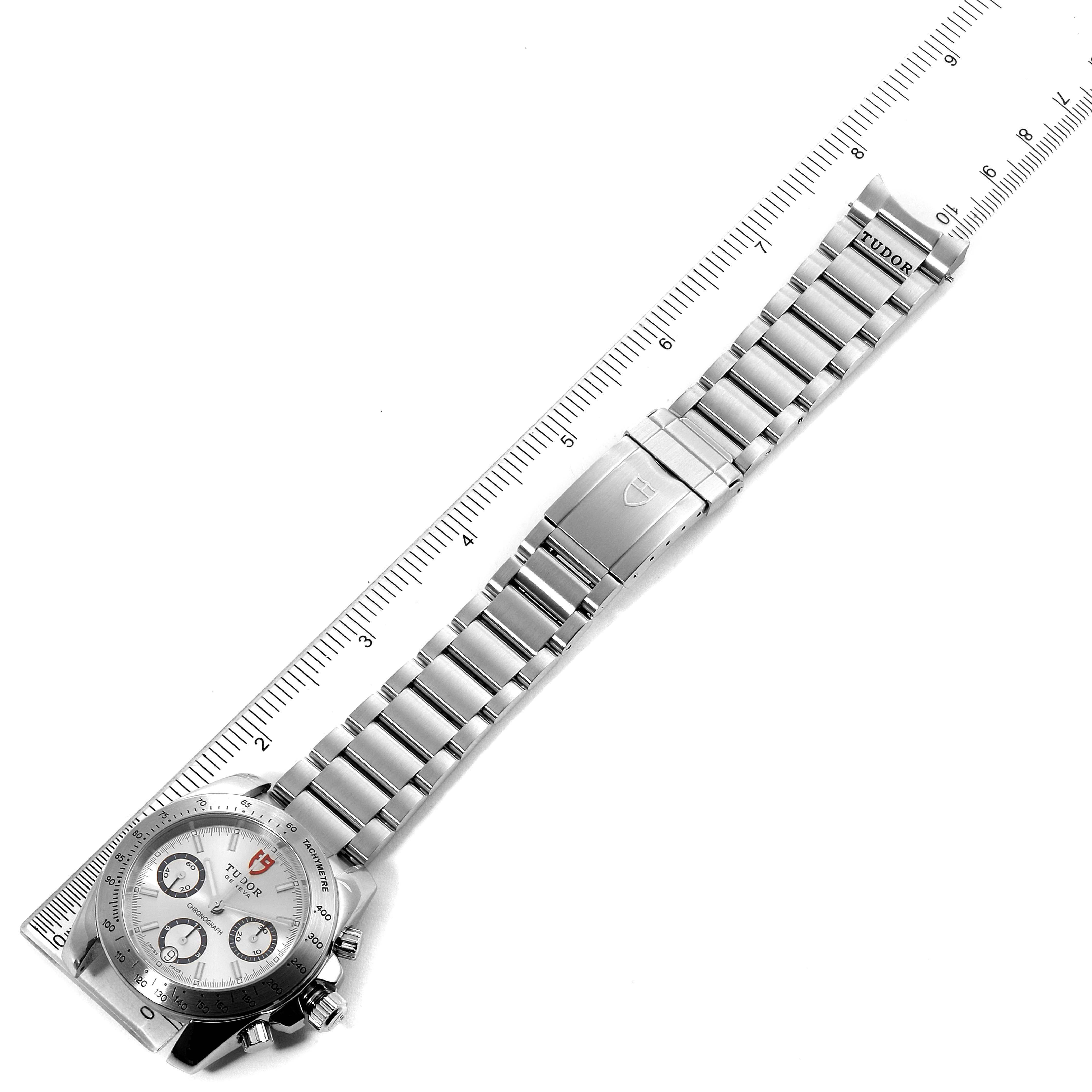 The Tudor Sport Chronograph 20300 Men's Stainless Steel Silver Dial 20300 Men's Stainless Steel Silver Dial watch is shown from a top-down angle, displaying its face, metal bracelet, clasp, and ruler for scale.