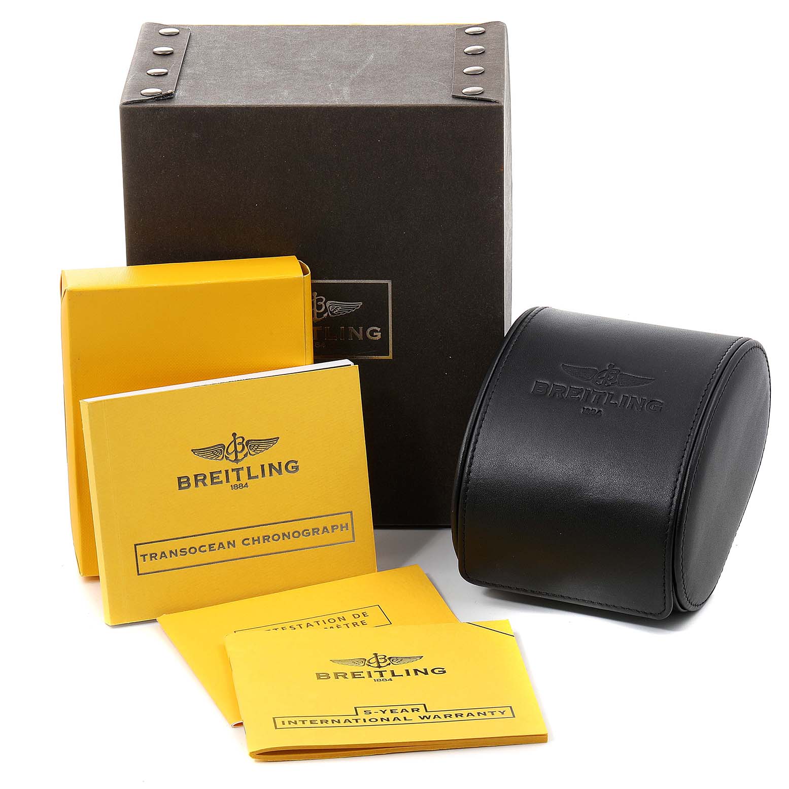 The Transocean model by Breitling is shown with its black watch case, packaging box, and accompanying yellow booklets.