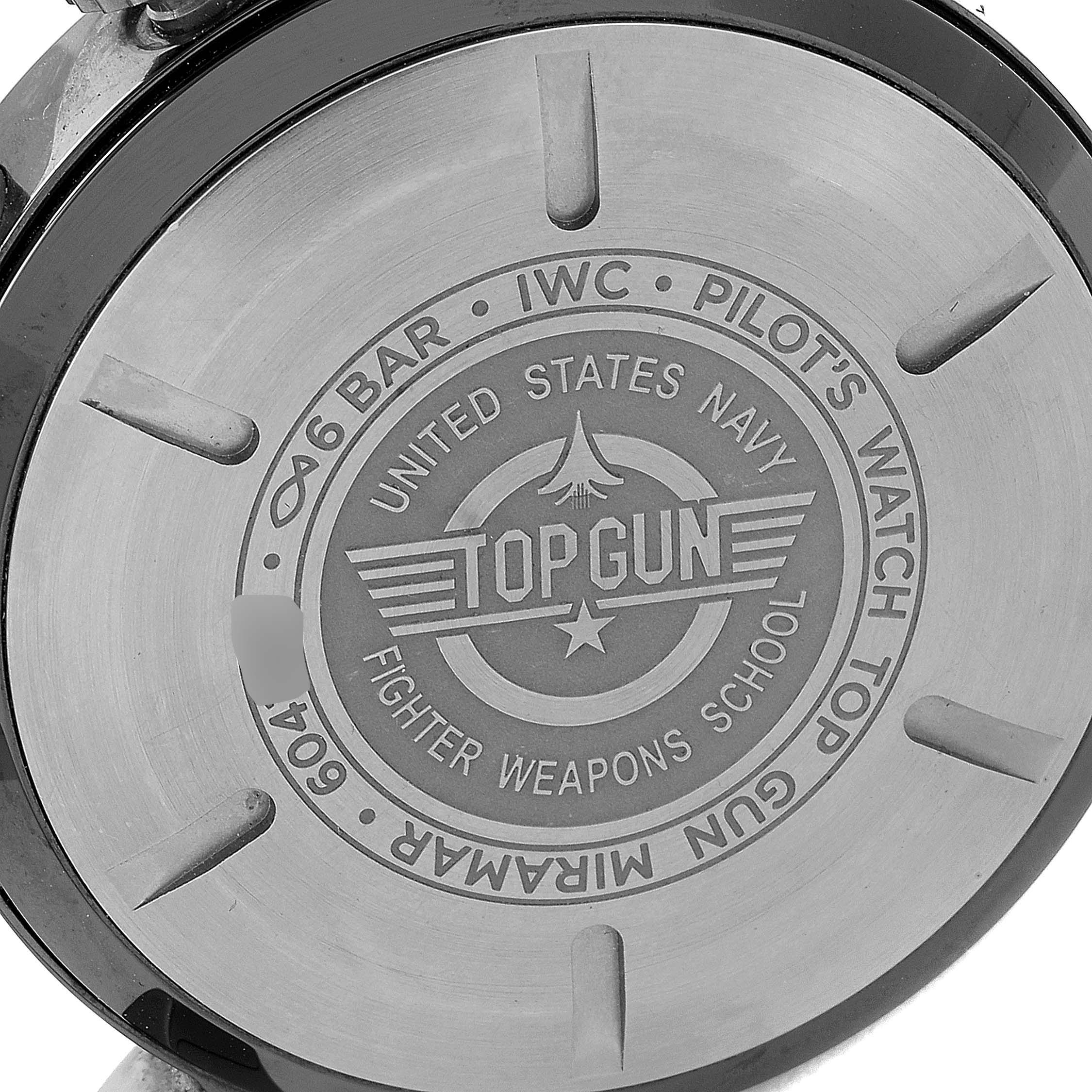 The image shows the back case of an IWC Pilot IW389002 Men's Ceramic Black Dial IW389002 Men's Ceramic Black Dial model watch, featuring "TOP GUN" and other inscriptions.
