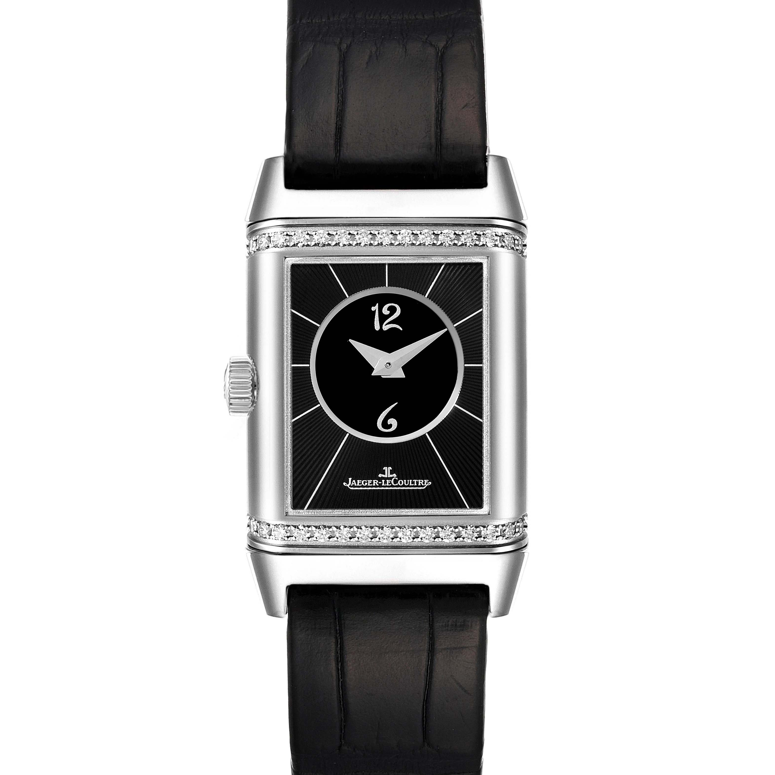 The image shows a front view of the Jaeger-LeCoultre Reverso watch, highlighting its rectangular face, diamond bezel, and black leather strap.