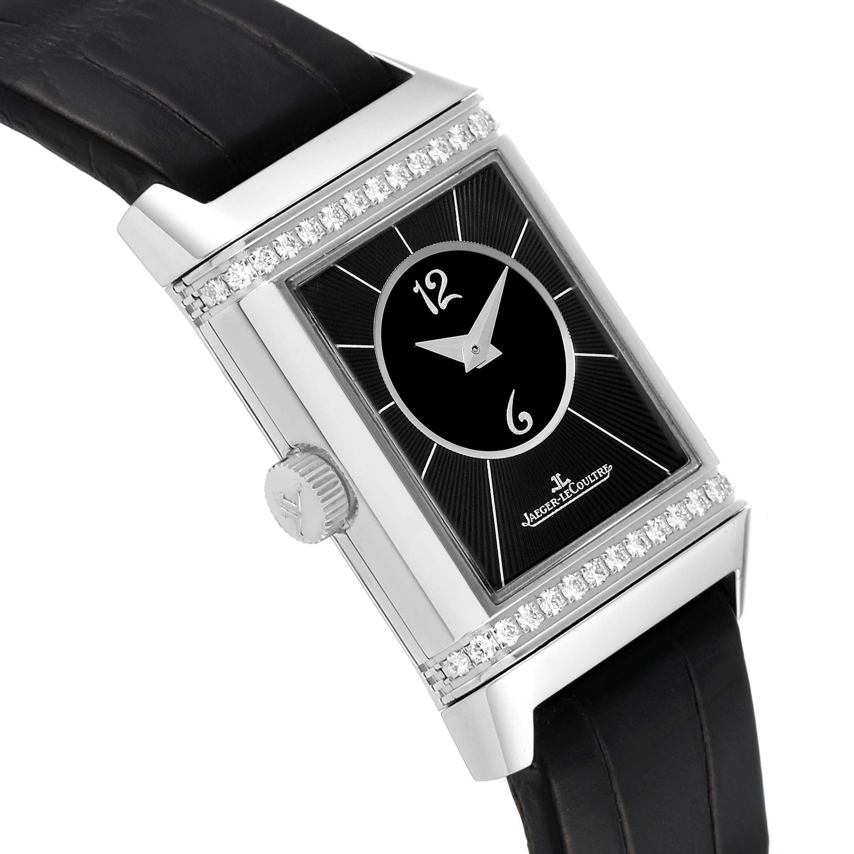 This Jaeger LeCoultre Reverso Q2668430 Women's Stainless Steel Silver Dial Q2668430 Women's Stainless Steel Silver Dial watch is shown from an angled side view, highlighting its black strap, rectangular face, diamonds, and crown.