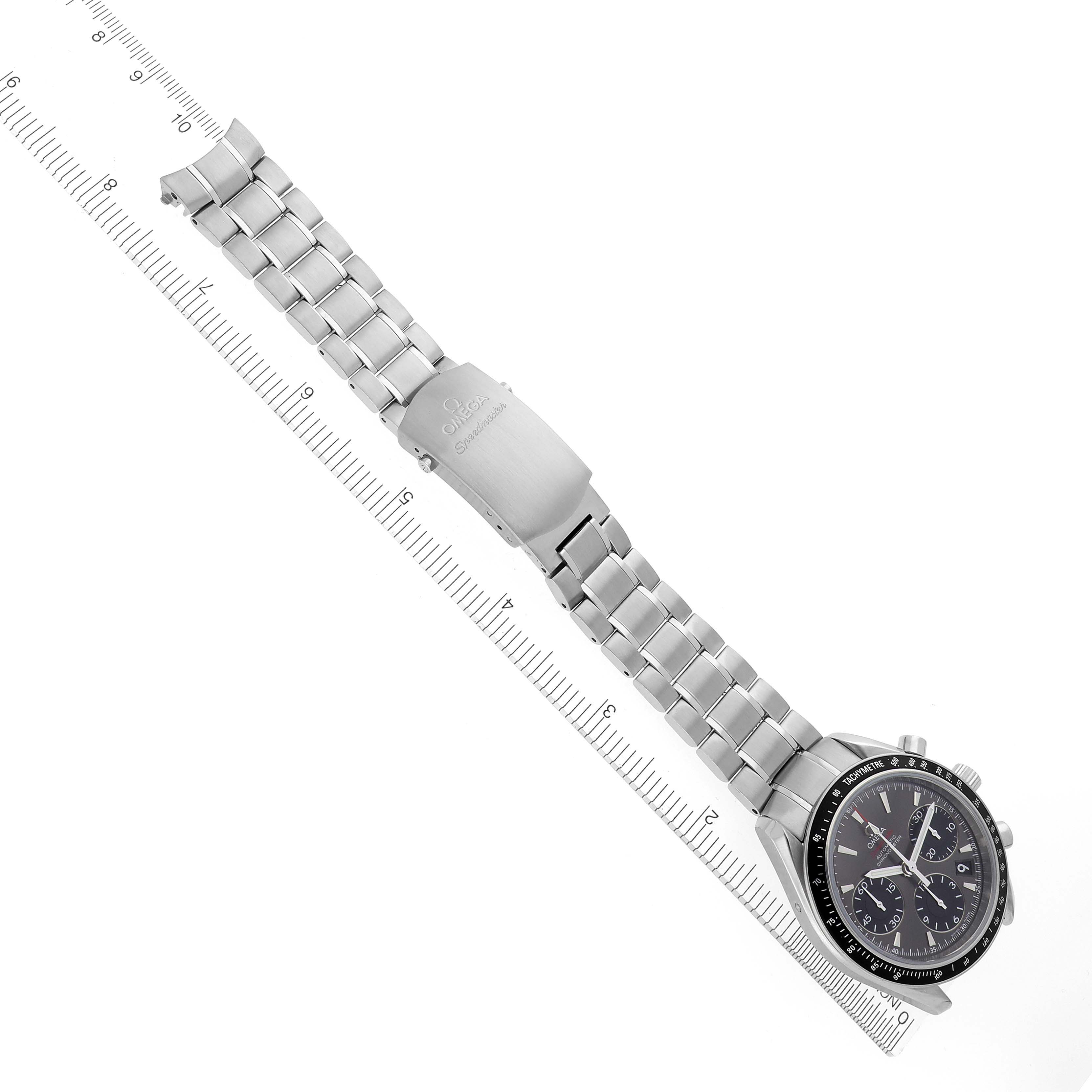 The Omega Speedmaster 323.30.40.40.06.001 Men's Stainless Steel Grey Dial 323.30.40.40.06.001 Men's Stainless Steel Grey Dial watch is shown from above, highlighting the bracelet, clasp, and face next to a measuring ruler.