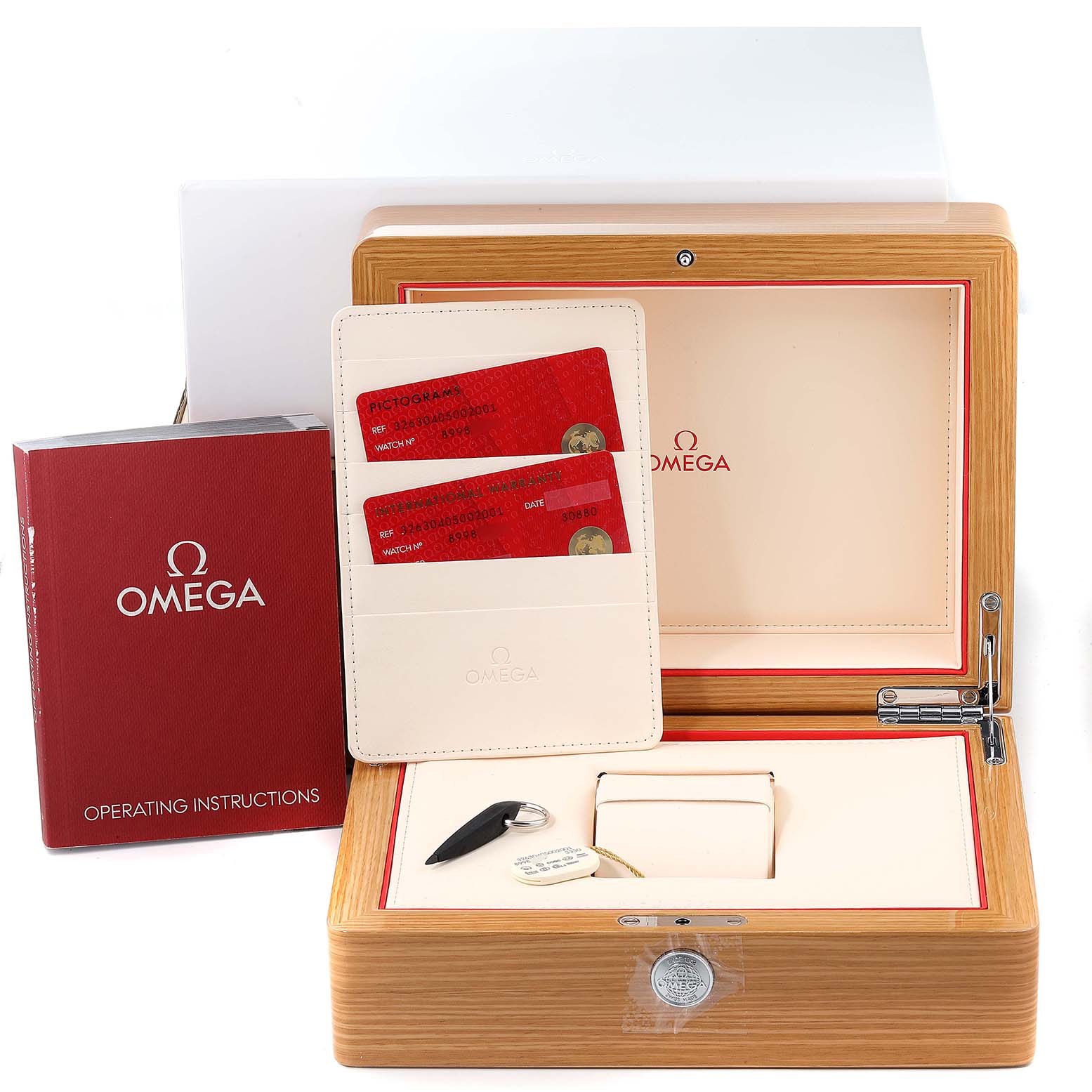 The image shows the Omega Speedmaster 326.30.40.50.02.001 Men
s Stainless Steel Silver Dial 326.30.40.50.02.001 Men
s Stainless Steel Silver Dial presentation box, operating instructions, warranty cards, and watch accessories from a front angle.