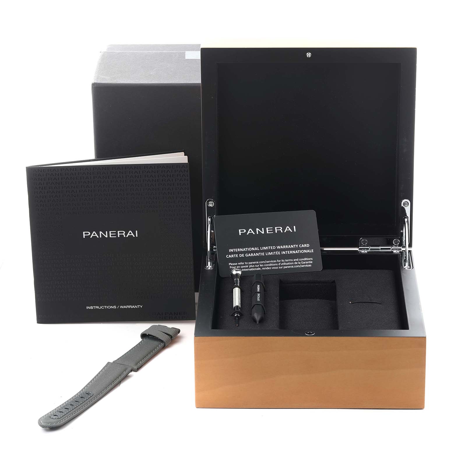The image shows the open box of a Panerai Luminor PAM02973 Men's Stainless Steel Black Dial PAM02973 Men's Stainless Steel Black Dial watch model, with a strap, tools, and warranty booklet visible.