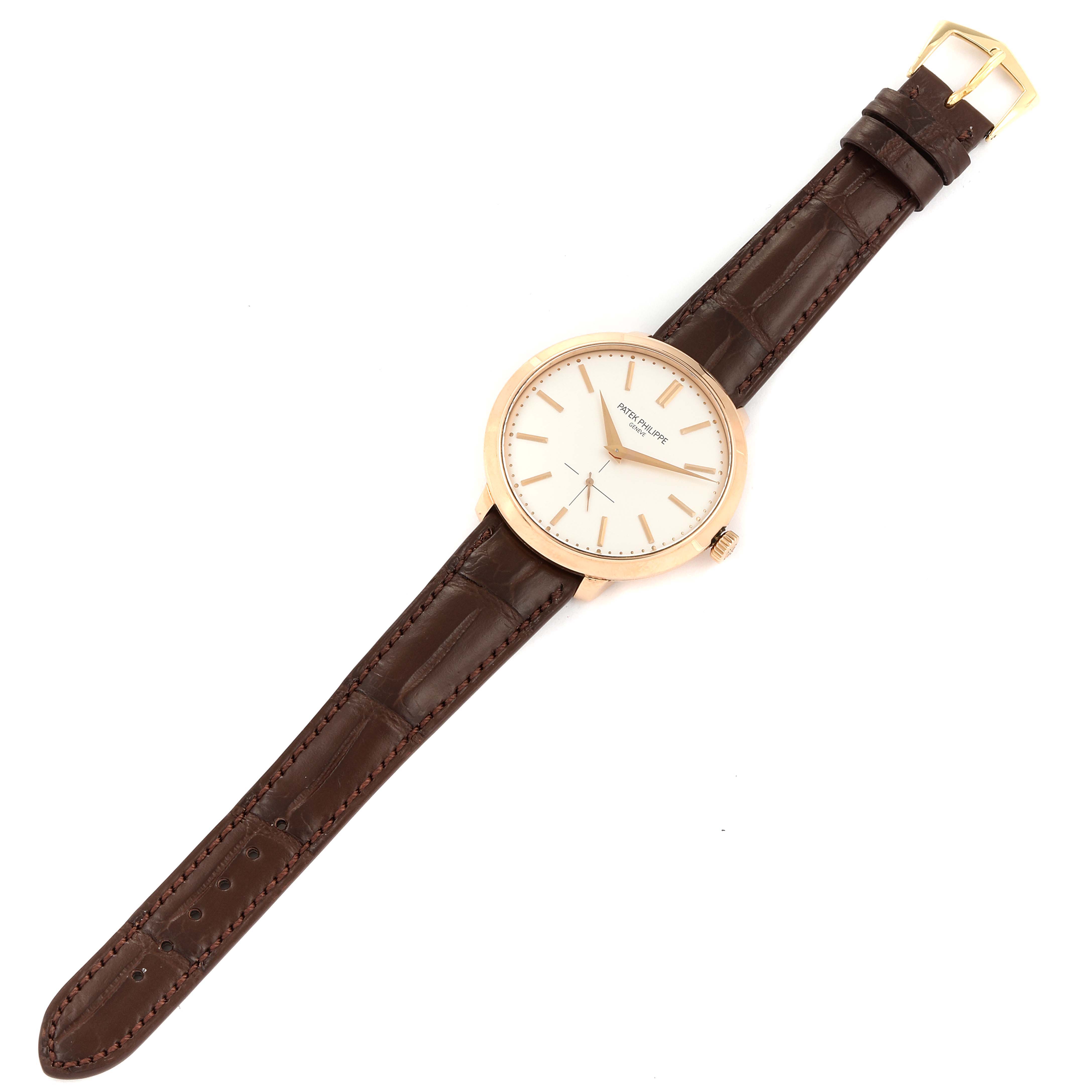 The Calatrava model by Patek Philippe is shown from a top-down angle, featuring its watch face, crown, and leather strap.