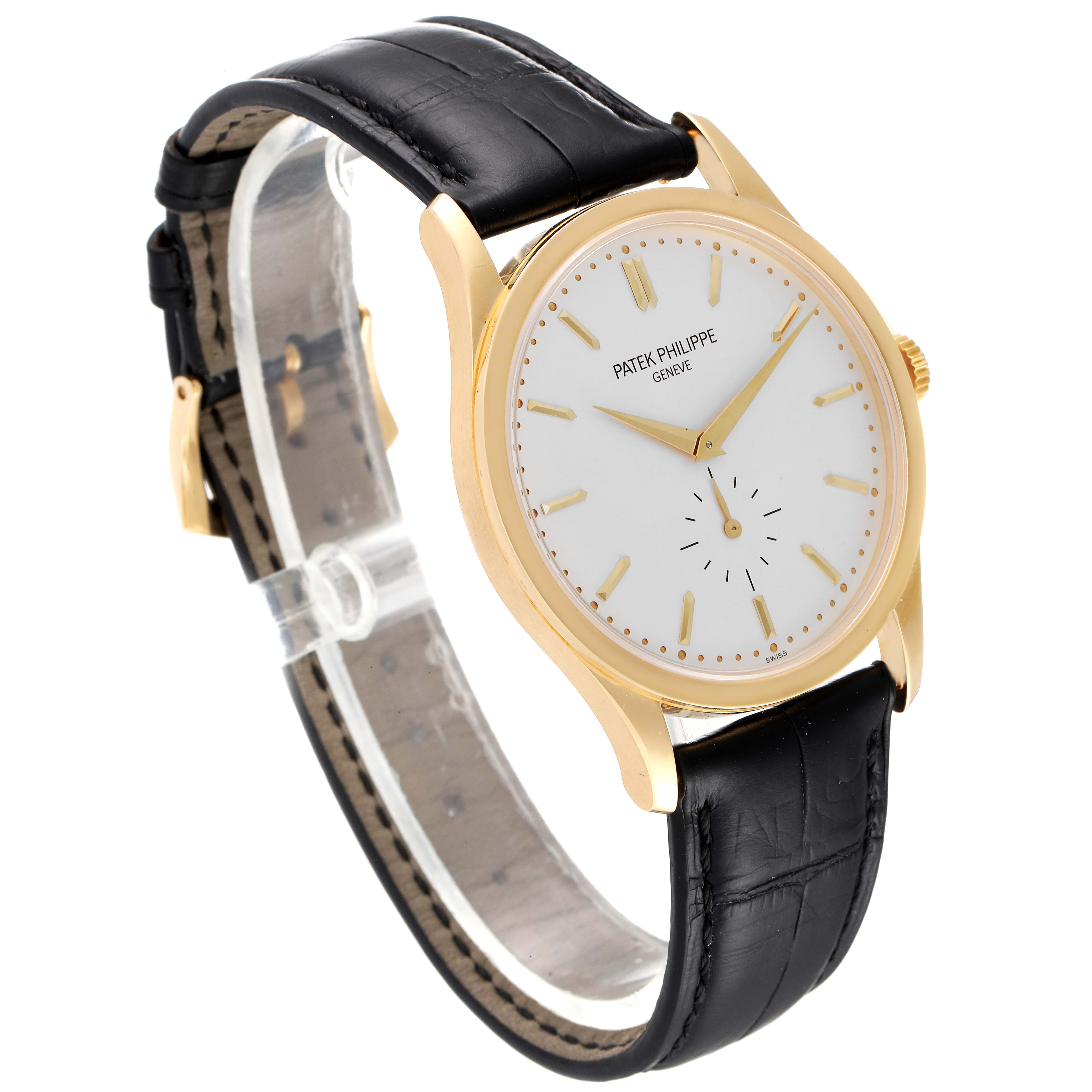 The image shows a Patek Philippe Calatrava 5196J Men's Yellow Gold Silver Dial 5196J Men's Yellow Gold Silver Dial watch at a three-quarter angle displaying its face, black leather strap, and gold casing.