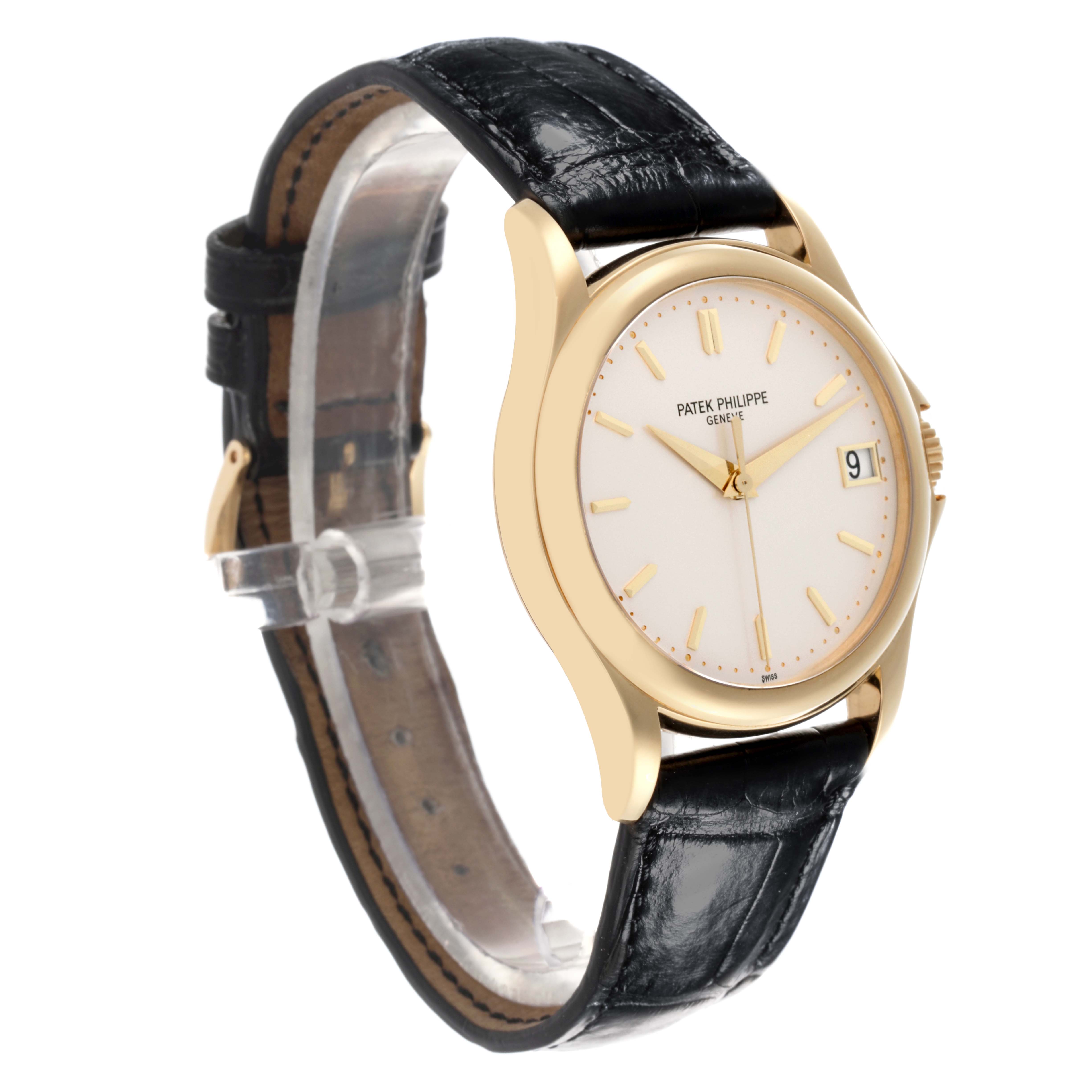 The Patek Philippe Calatrava 5127J-001 Men's Yellow Gold Silver Dial 5127J-001 Men's Yellow Gold Silver Dial watch is shown at a three-quarter angle, displaying the face, gold case, and black leather strap.