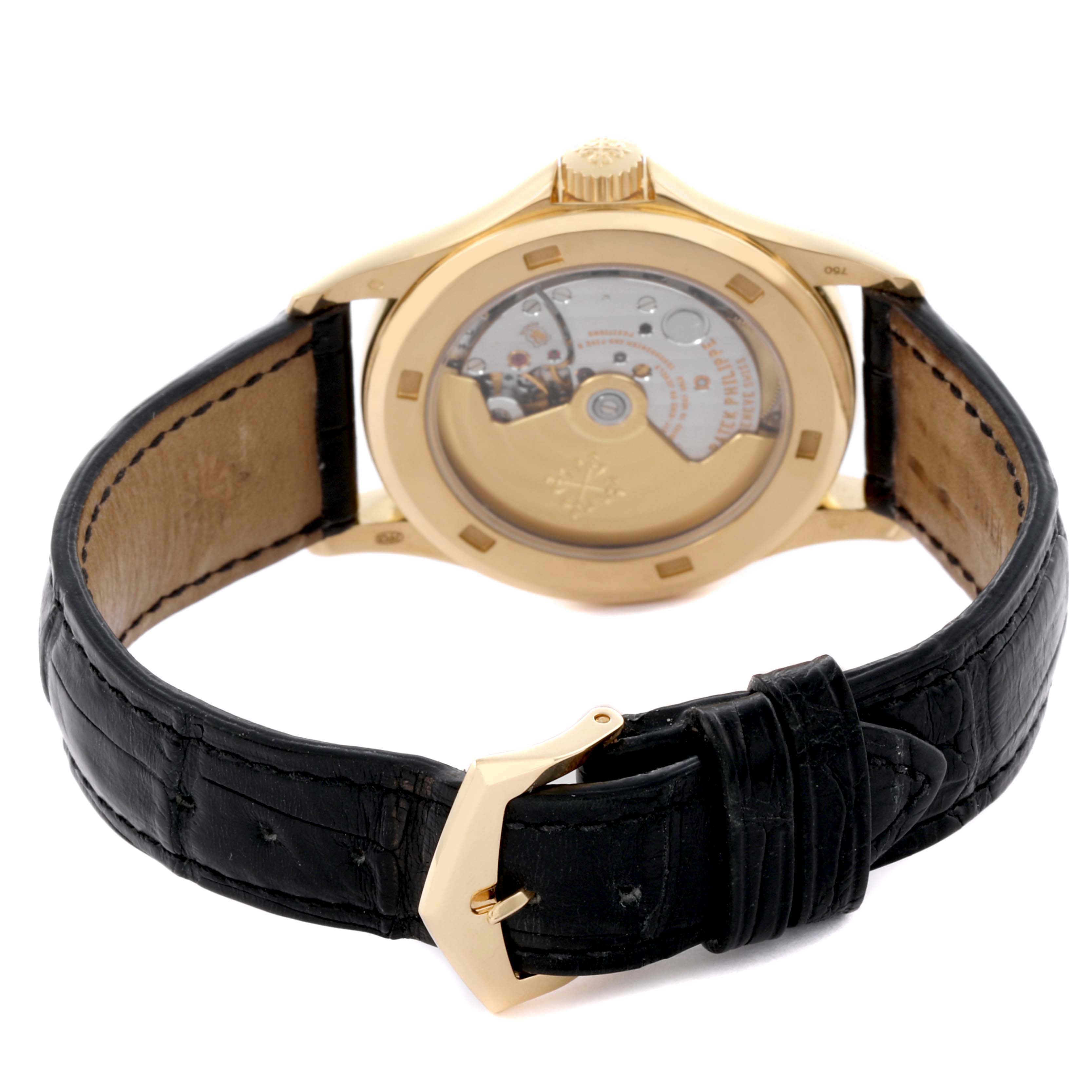 The image shows the back of the Patek Philippe Calatrava 5127J-001 Men's Yellow Gold Silver Dial 5127J-001 Men's Yellow Gold Silver Dial watch, highlighting its open case back and leather strap.