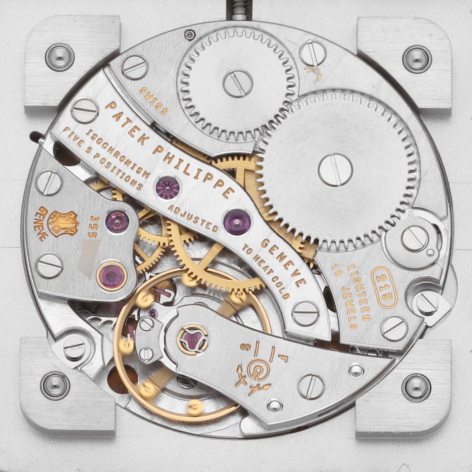 The image shows the intricate movement of a Patek Philippe Gondolo 5111G-001 Men's White Gold Silver Dial 5111G-001 Men's White Gold Silver Dial watch, highlighting gears, jewels, and engravings from a top view.