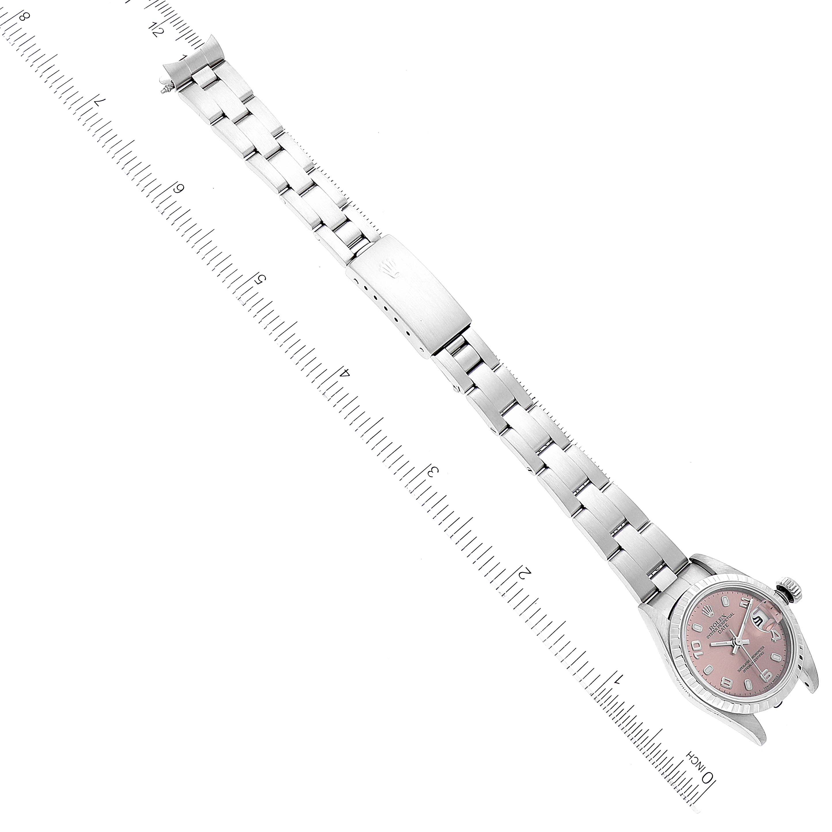 This image shows a top-down view of a Rolex Date 79240 Women's Stainless Steel Pink Dial 79240 Women's Stainless Steel Pink Dial model watch, displaying the dial, bracelet, and clasp adjacent to a ruler for measurement.