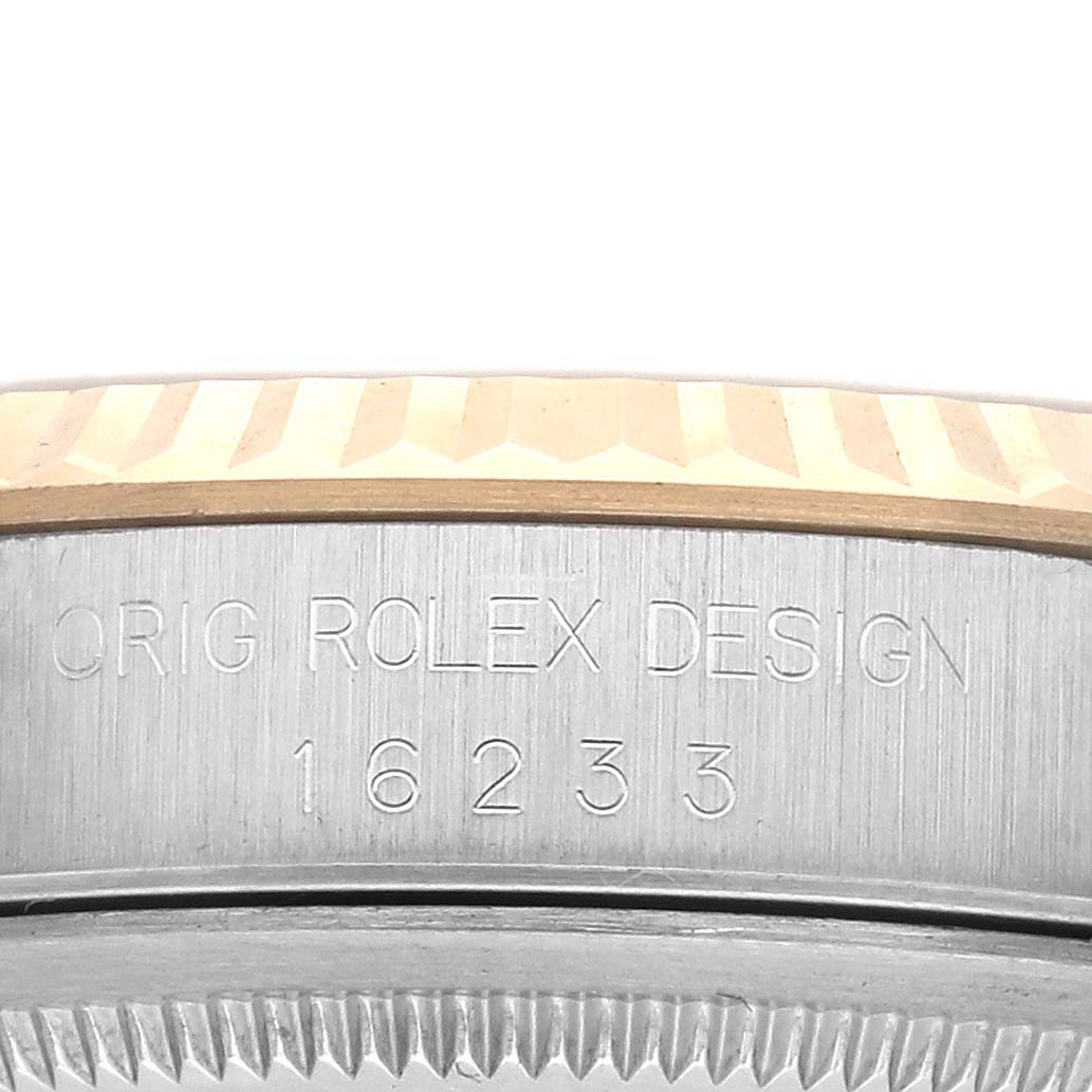 The image shows a side view of a Rolex Datejust 16233 Men's Steel and Gold (two tone) Champagne Dial 16233 Men's Steel and Gold (two tone) Champagne Dial, focusing on the engraved bezel and casing.