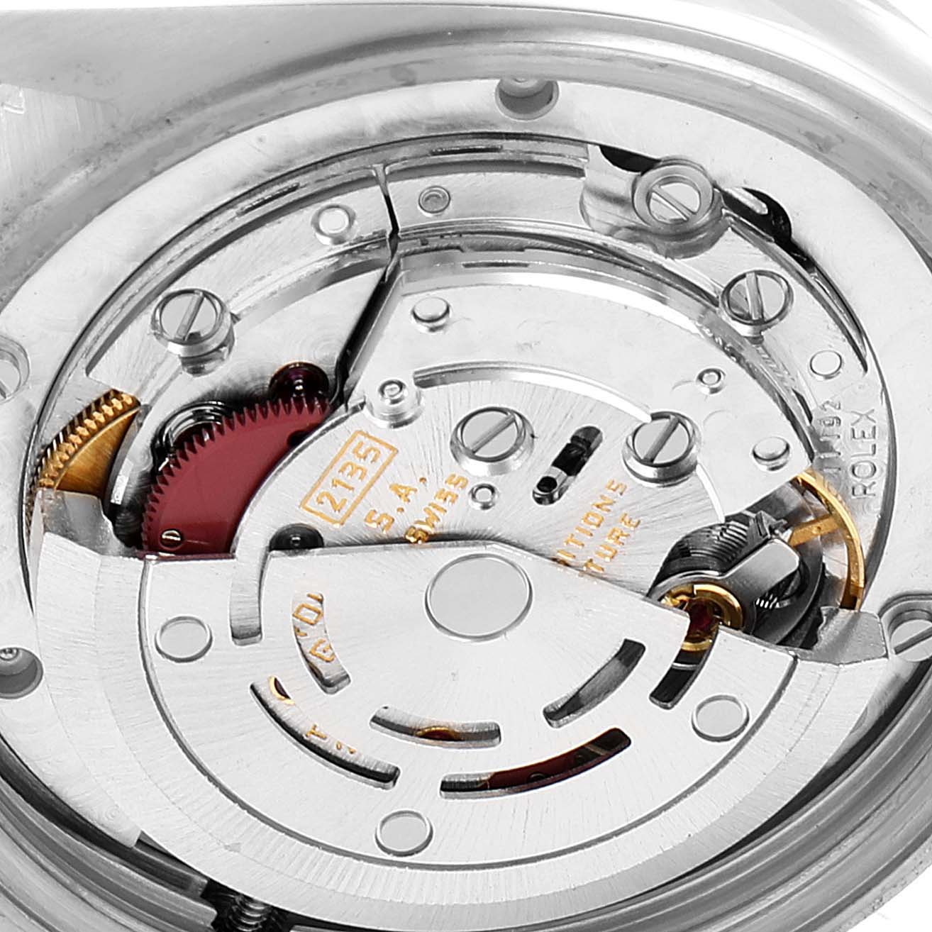 This image shows the internal movement mechanism of a Mid-Size Rolex watch, featuring gears and intricate components.