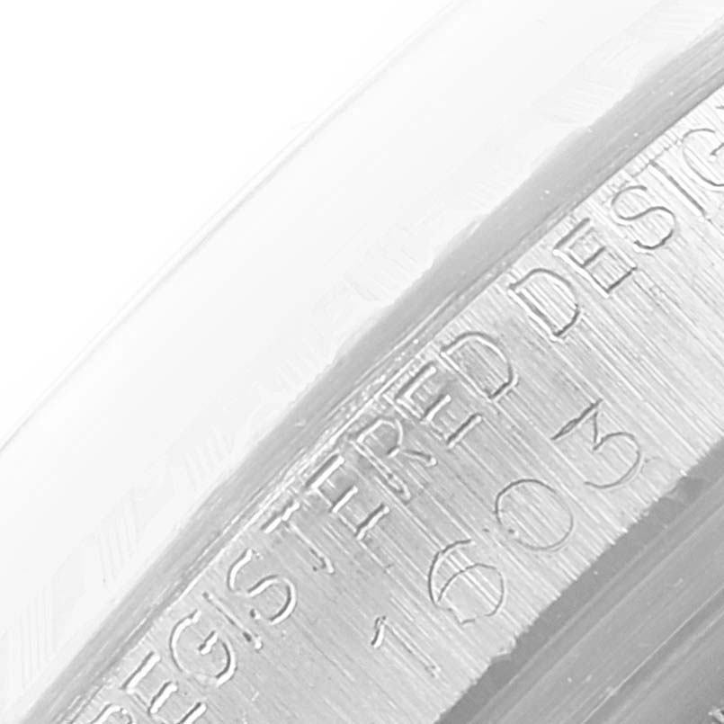This is a close-up of the engraved case edge of a Rolex Datejust 1603 Men
s Stainless Steel Silver Dial 1603 Men
s Stainless Steel Silver Dial watch, showing part of the "REGISTERED DESIGN" inscription.