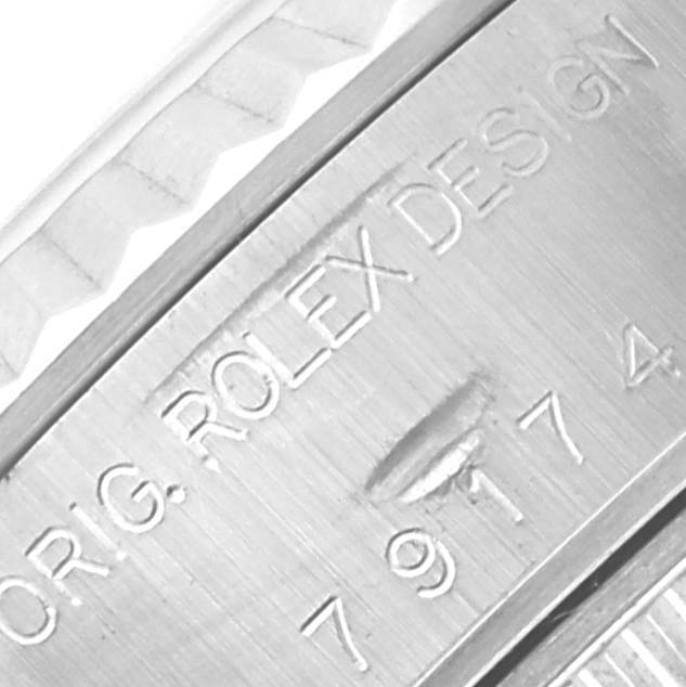 The image shows a close-up of the Rolex Datejust 79174 Women's Stainless Steel Silver Dial 79174 Women's Stainless Steel Silver Dial case engraving, highlighting text and design details.