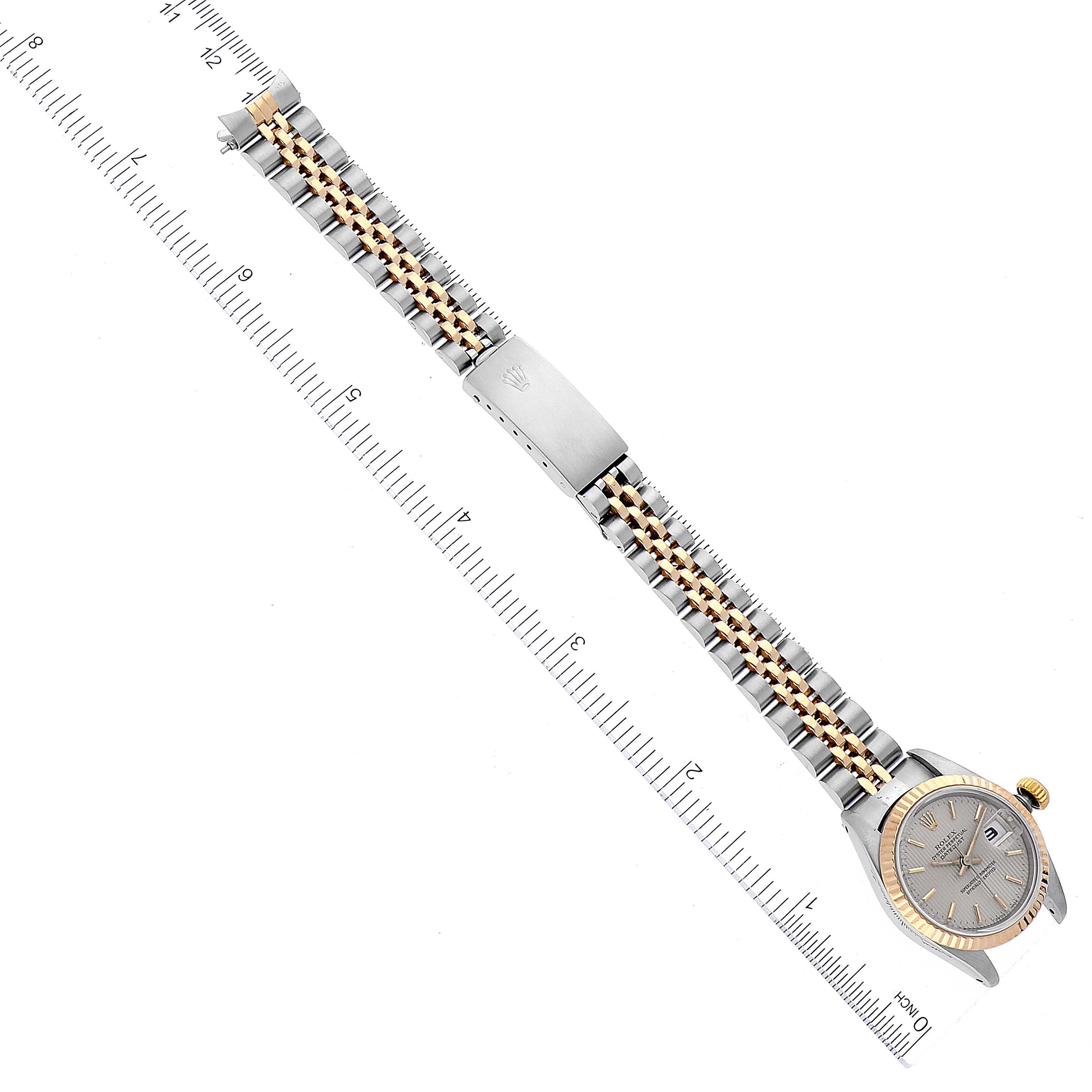 The image shows a top view of a Rolex Datejust 69173 Women's Steel and Gold (two tone) Silver Dial 69173 Women's Steel and Gold (two tone) Silver Dial watch displaying its dial, bracelet, and clasp, aligned next to a ruler.