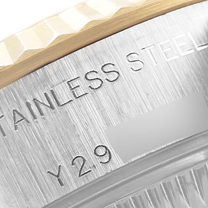 This close-up image of a Rolex Datejust 79173 Women's Steel and Gold (two tone) Pink Dial 79173 Women's Steel and Gold (two tone) Pink Dial watch shows part of the bezel and the caseback with engraved text.