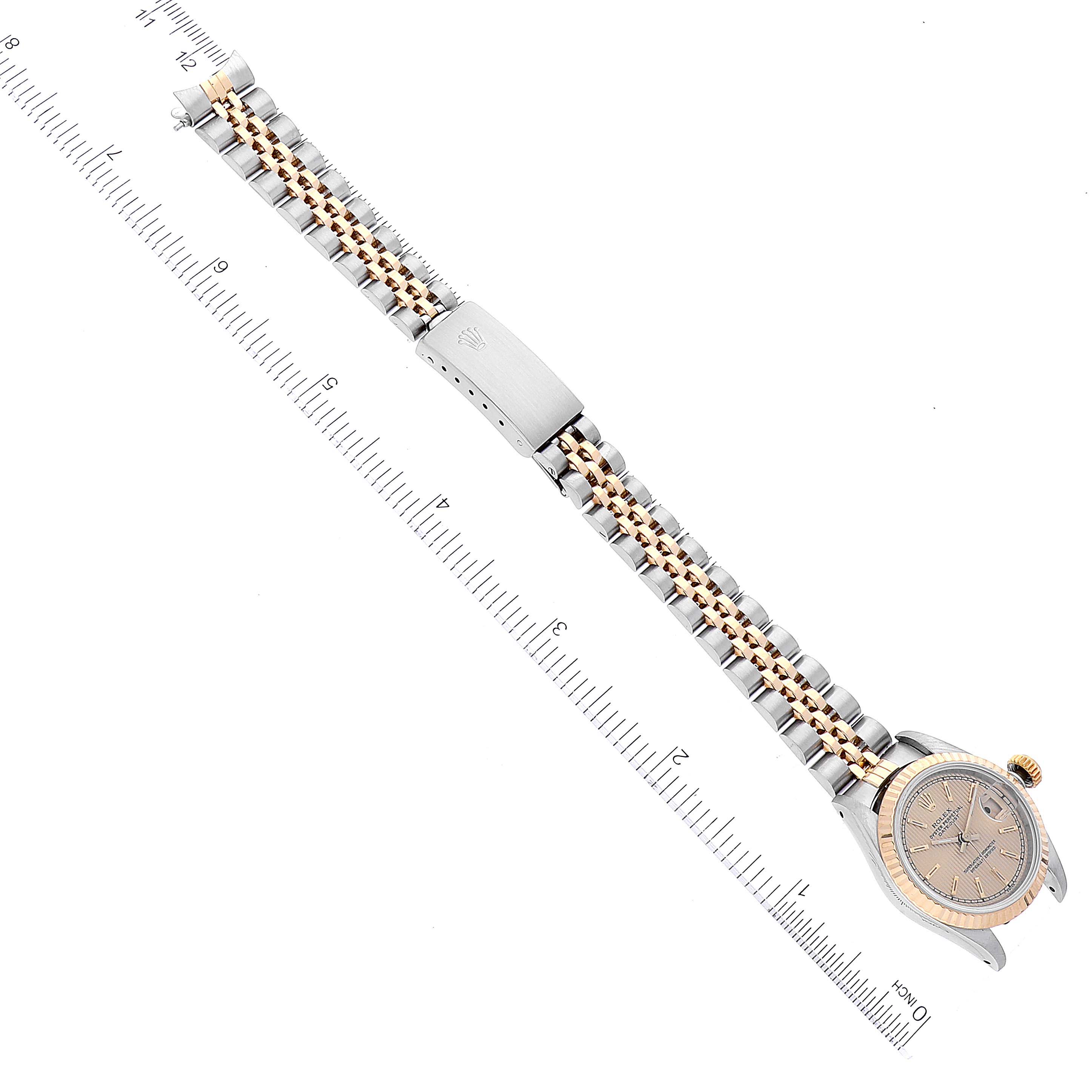 This image shows the Rolex Datejust 69173 Women's Steel and Gold (two tone) Champagne Dial 69173 Women's Steel and Gold (two tone) Champagne Dial watch from an overhead angle, focusing on the bracelet and dial alongside a ruler.