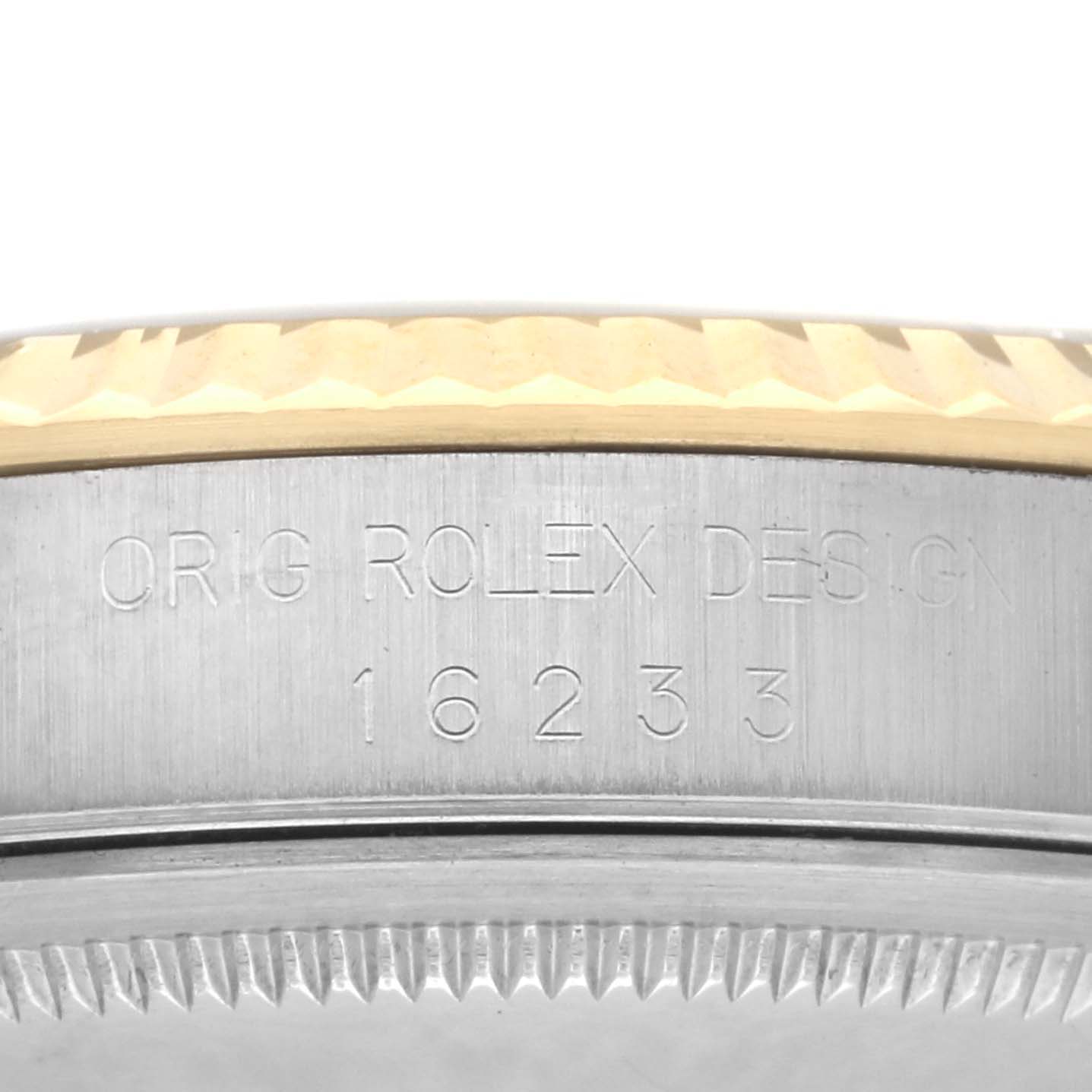 The image shows a side view of a Rolex Datejust 16233 Men's Steel and Gold (two tone) White Dial 16233 Men's Steel and Gold (two tone) White Dial watch bezel and serial engraving.