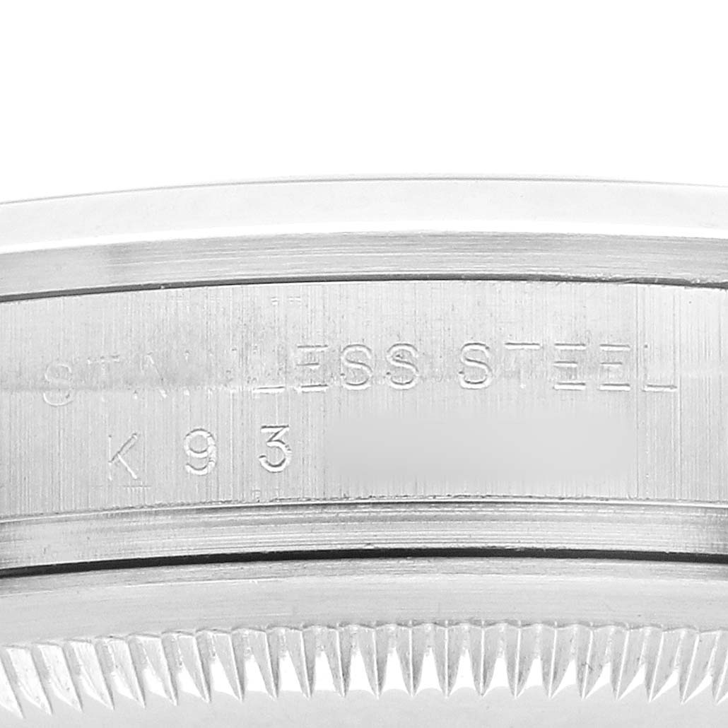 The image shows a close-up of the case back edge of a Rolex Explorer 114270 Men's Stainless Steel Black Dial watch, highlighting the engraved "STAINLESS STEEL" text.