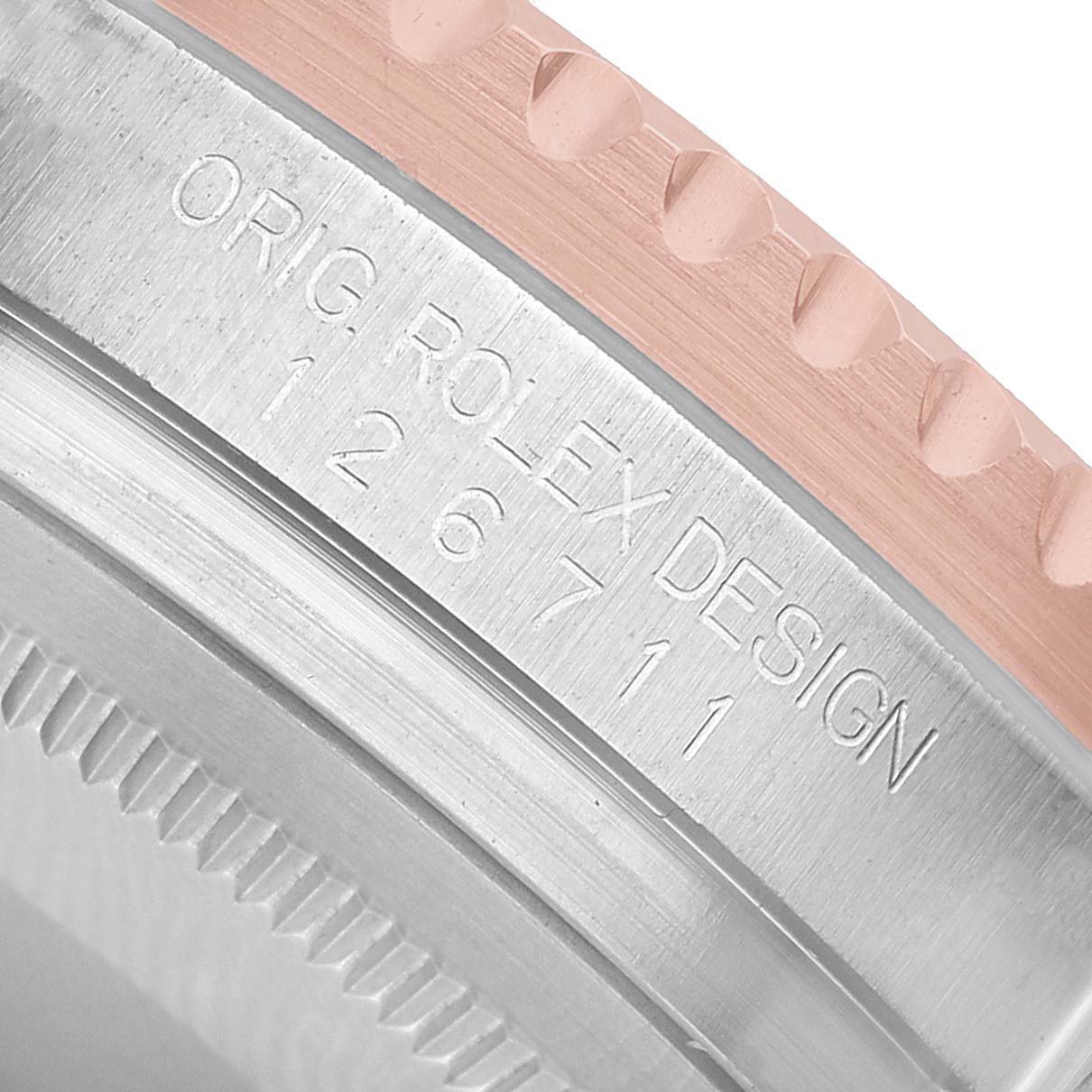 The image shows a close-up of the Rolex GMT-Master 126711 Men's Steel and Gold (two tone) Black Dial model's bezel edge and engraved case side.