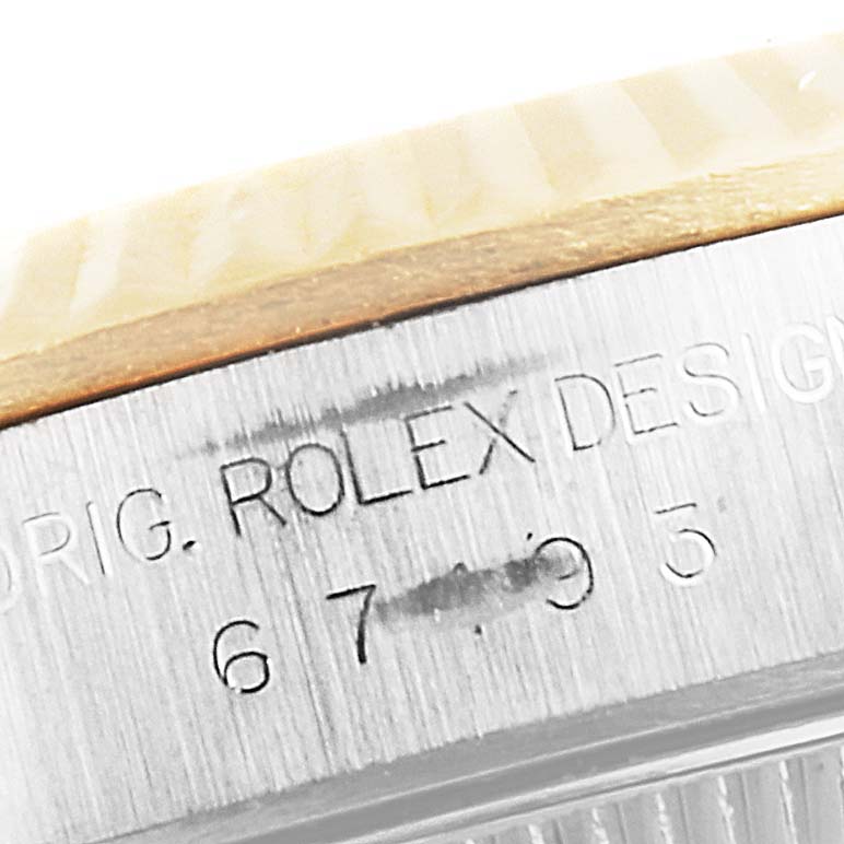 This image shows a close-up of the side engraving on the case of a Rolex Oyster Perpetual 67193 Women's Steel and Gold (two tone) Champagne Dial 67193 Women's Steel and Gold (two tone) Champagne Dial watch.