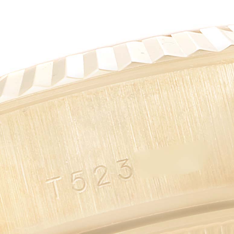 This is a close-up view of the Rolex President 69178 Women
s Yellow Gold Champagne Dial 69178 Women
s Yellow Gold Champagne Dial watch, showing part of the bezel and serial number engraving.