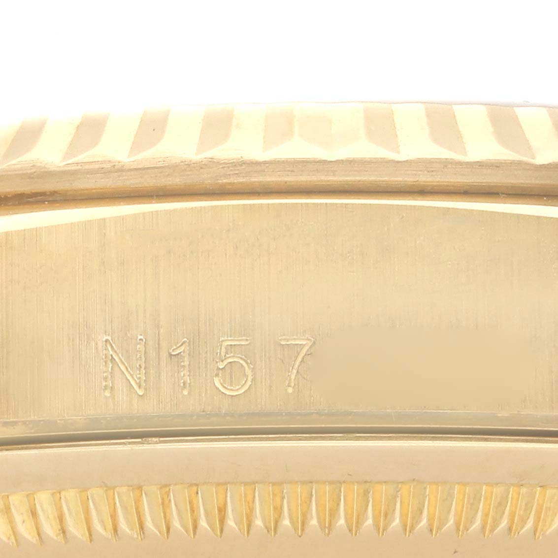 The image shows a close-up of the engraved side of the case of a Rolex President 18338 Men's Yellow Gold Champagne Dial 18338 Men's Yellow Gold Champagne Dial model.