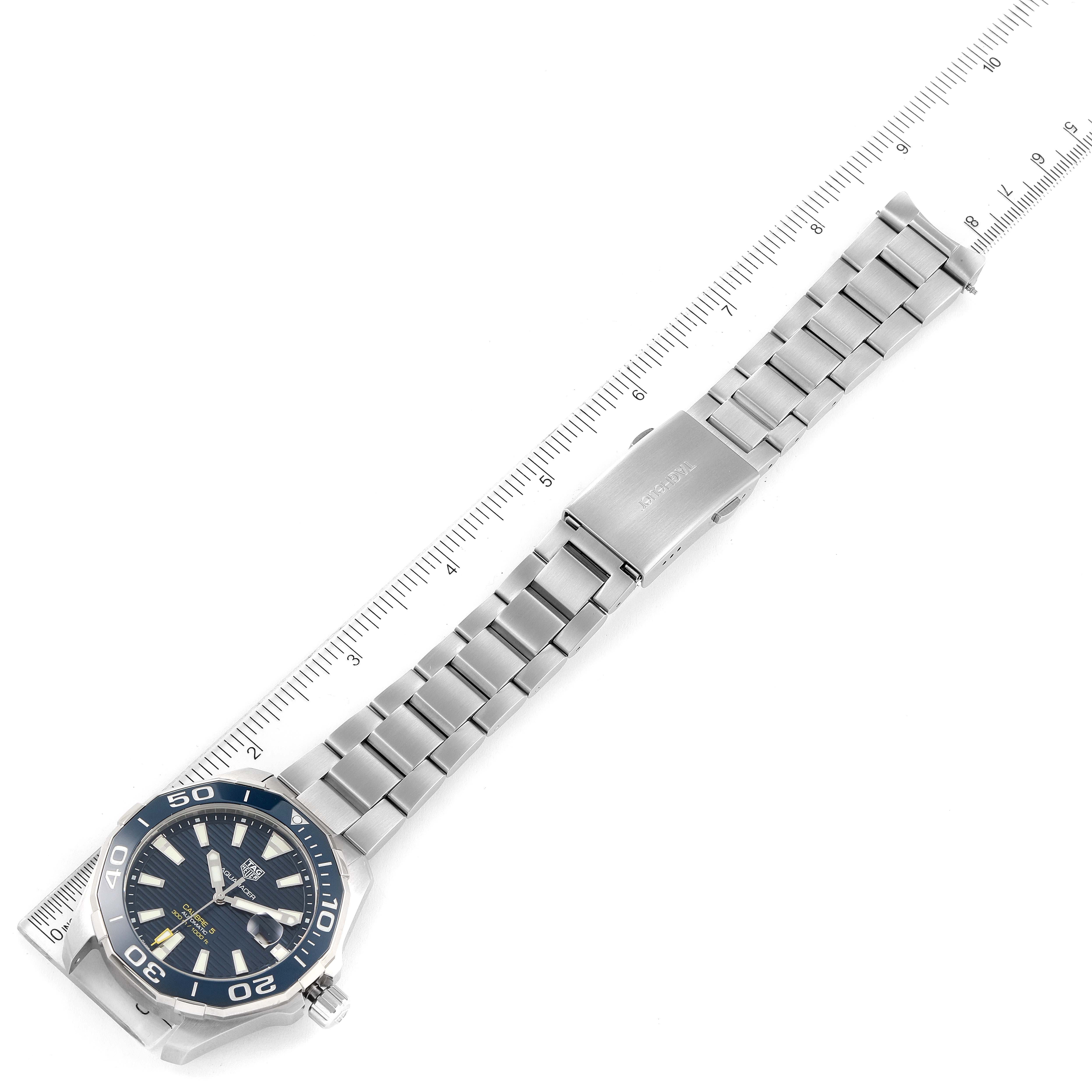 The image shows an overhead view of a Tag Heuer Aquaracer WAY201B Men's Stainless Steel Blue Dial WAY201B Men's Stainless Steel Blue Dial watch with a metal bracelet and part of a measuring scale.