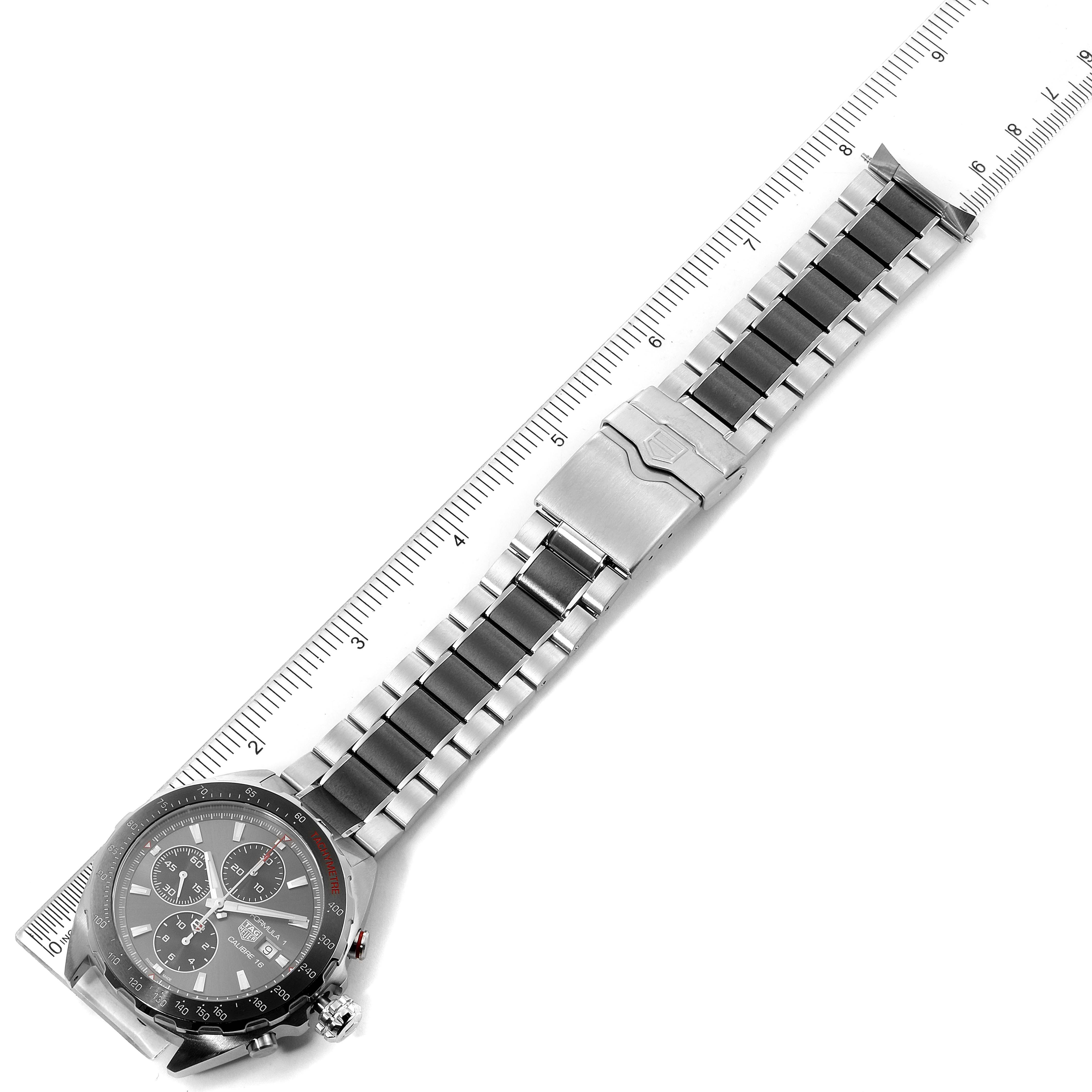 The image shows a Tag Heuer Formula 1 CAZ2012.BA0970 Men's Stainless Steel Grey Dial CAZ2012.BA0970 Men's Stainless Steel Grey Dial watch laid flat with the strap extended, displayed next to a ruler.