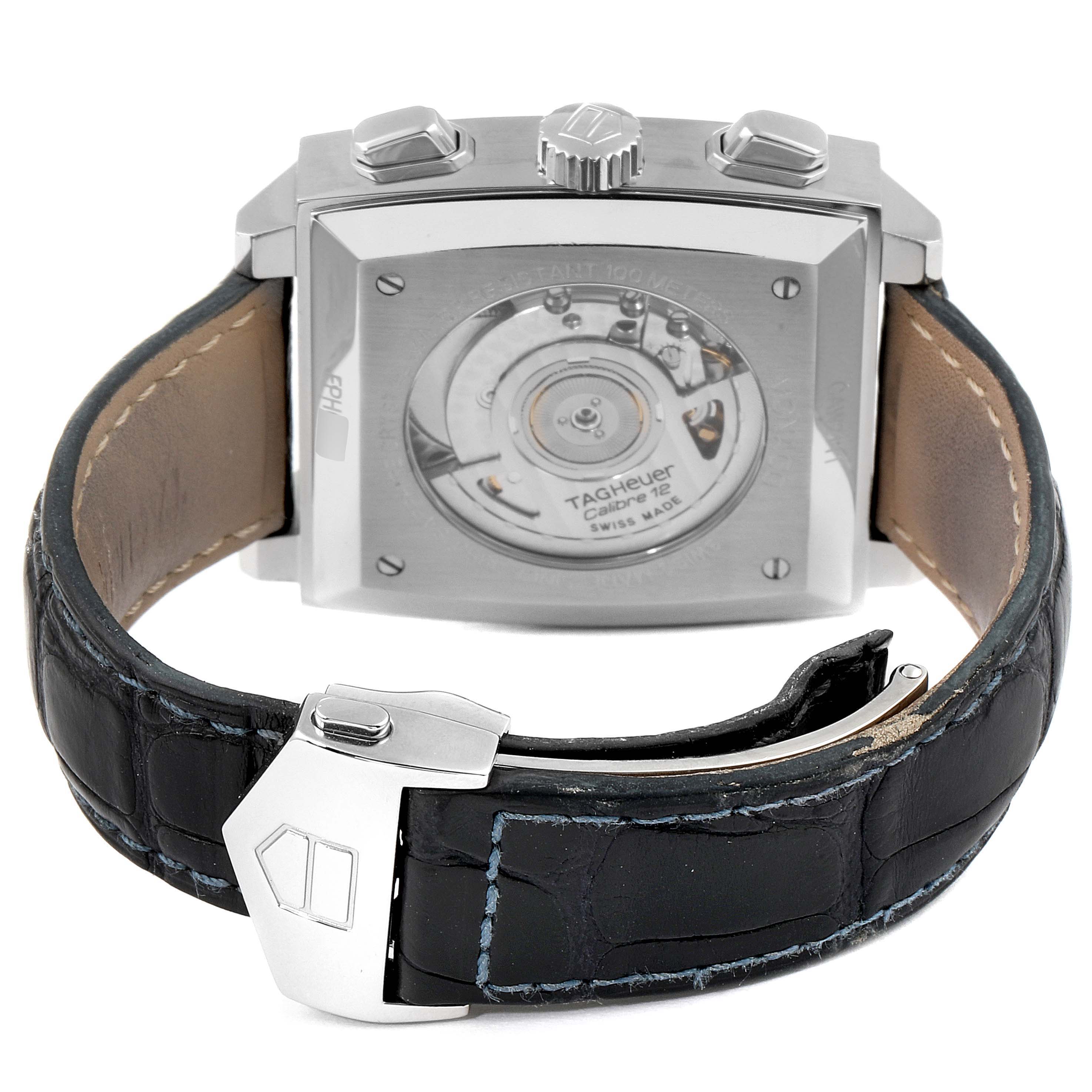 The image shows the back and clasp of the Tag Heuer Monaco CAW2111 Men's Stainless Steel Blue Dial CAW2111 Men's Stainless Steel Blue Dial model watch, highlighting its movement and leather strap with a stainless steel clasp.