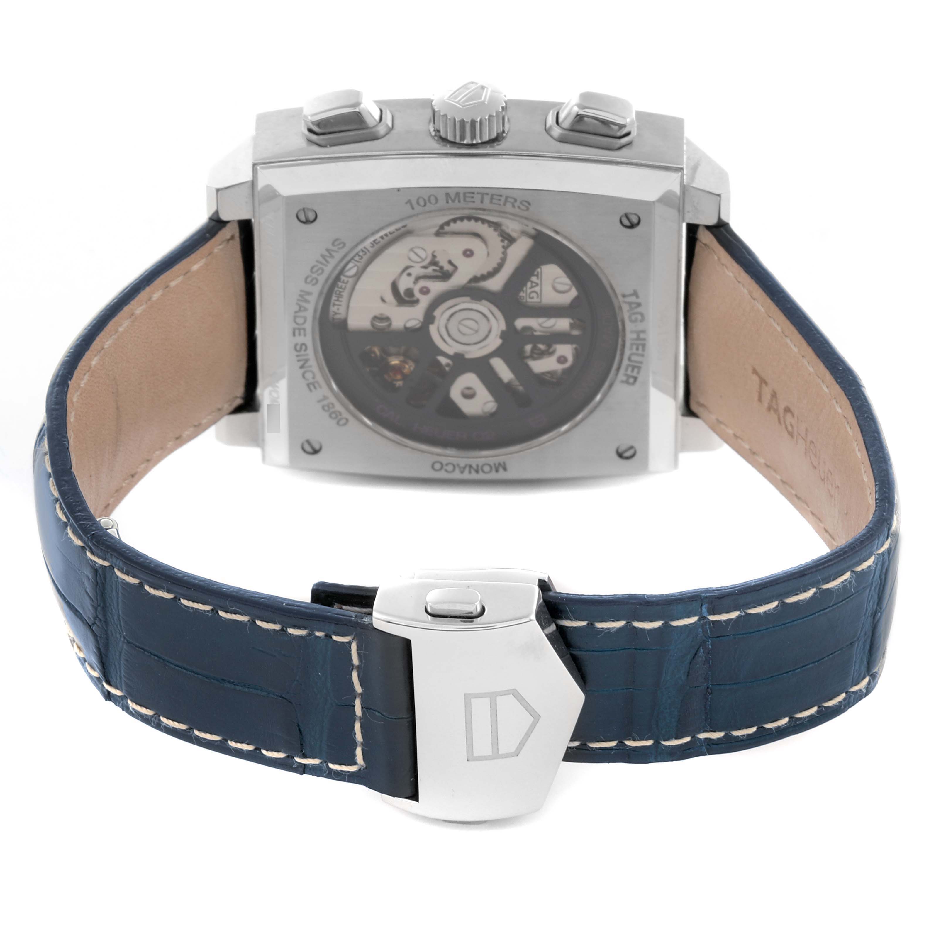 The Tag Heuer Monaco CBL2118.FC6518 Men's Stainless Steel Purple Dial CBL2118.FC6518 Men's Stainless Steel Purple Dial watch is shown from the back, displaying its exhibition case back and blue leather strap with a clasp.