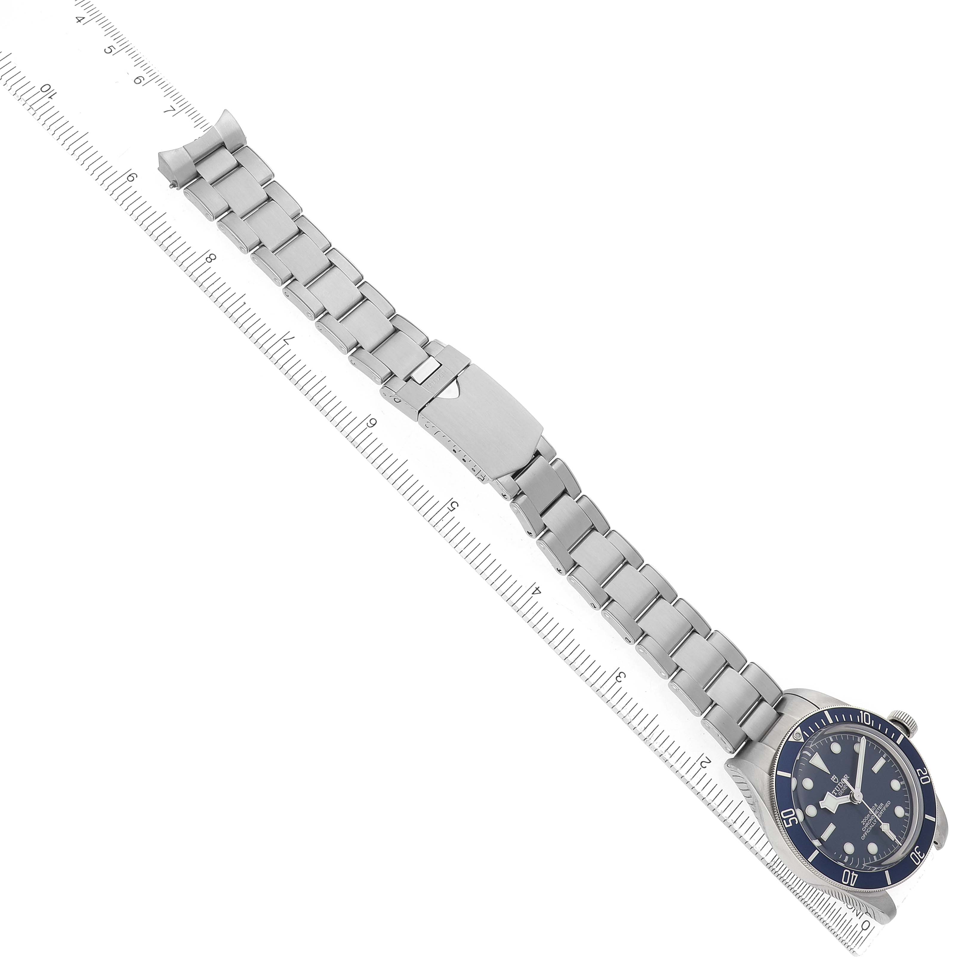 The Tudor Heritage Black Bay 79030B Men's Stainless Steel Blue Dial watch is shown at an angled top view, highlighting the bracelet, clasp, and face.