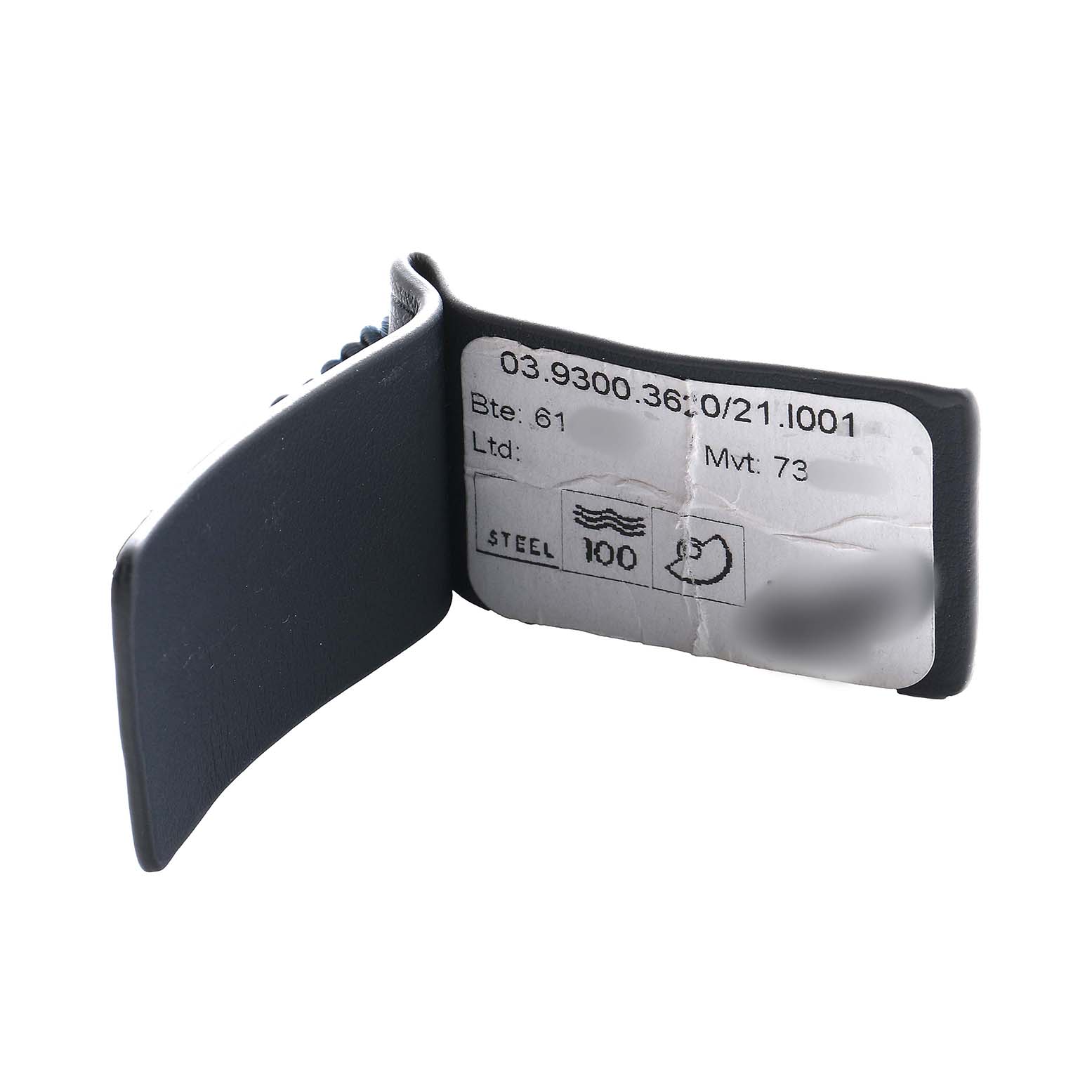 The image shows a Zenith Defy 03.9300.3620 Men's Stainless Steel Black Dial watch tag with model information and specifications, viewed from a side angle.