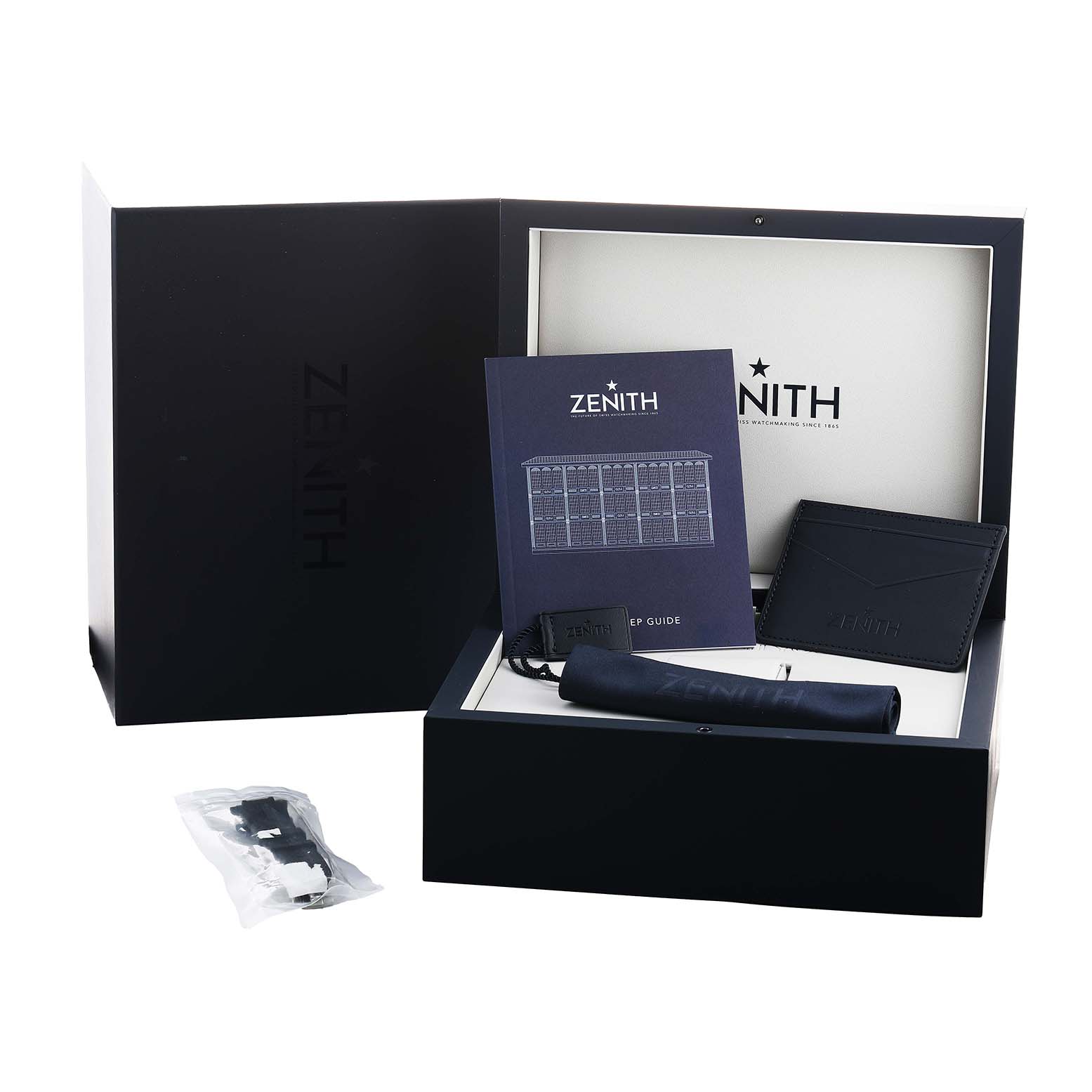 The Zenith Defy 03.9300.3620 Men's Stainless Steel Black Dial packaging shows an open box, booklet, case, and accessories from a front angle.