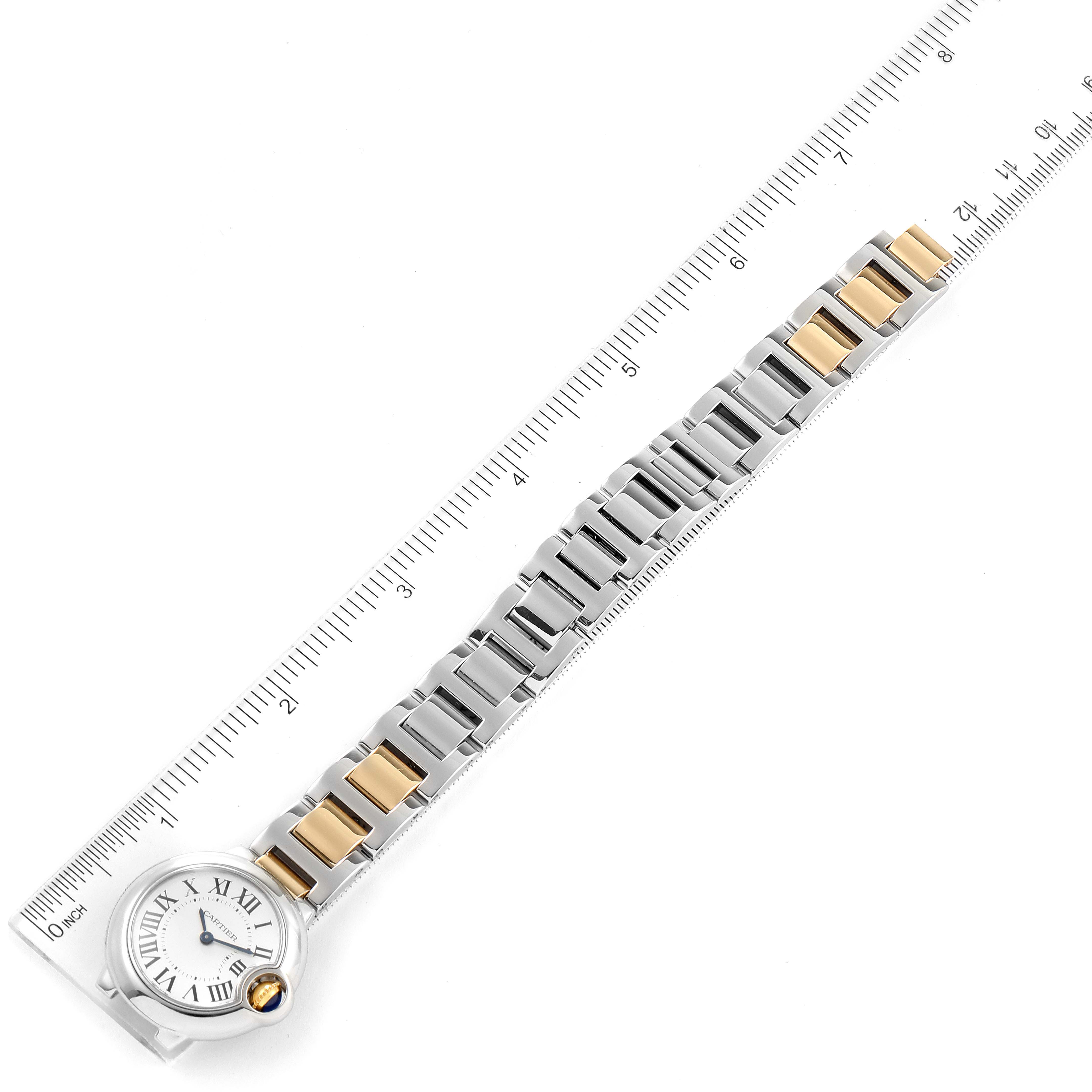 The image shows the Cartier Ballon Bleu W2BB0010 Women
s Steel and Gold (two tone) Silver Dial W2BB0010 Women
s Steel and Gold (two tone) Silver Dial watch laid flat with a metal and gold bracelet, placed alongside a measuring ruler.