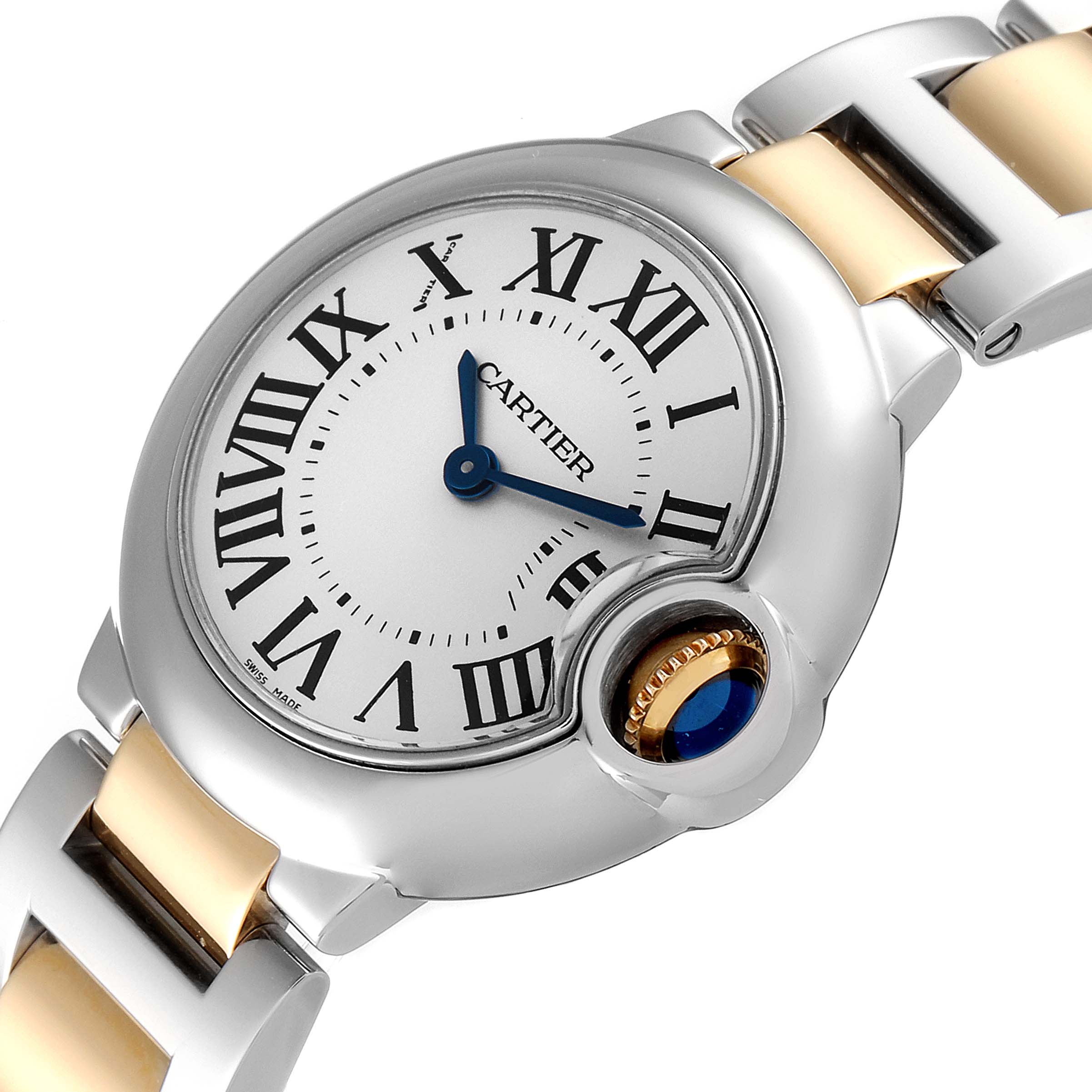 The image shows a detailed angle of the Cartier Ballon Bleu W2BB0010 Women's Steel and Gold (two tone) Silver Dial W2BB0010 Women's Steel and Gold (two tone) Silver Dial watch, focusing on its face, Roman numerals, hands, and part of the bracelet.