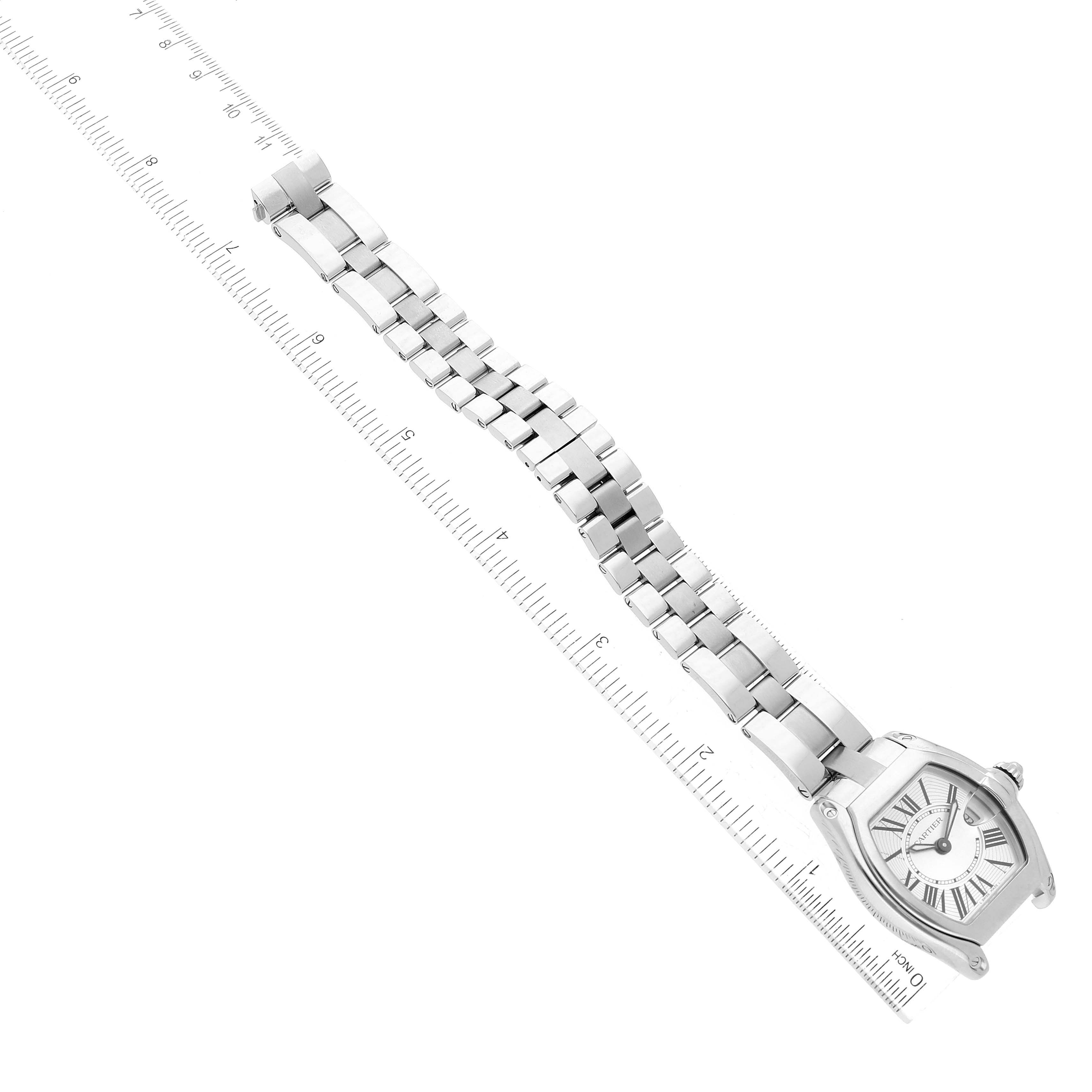 The Cartier Roadster W62016V3 Women's Stainless Steel Silver Dial W62016V3 Women's Stainless Steel Silver Dial watch is shown from an above angle, displaying its face, case, and metal bracelet next to a ruler.
