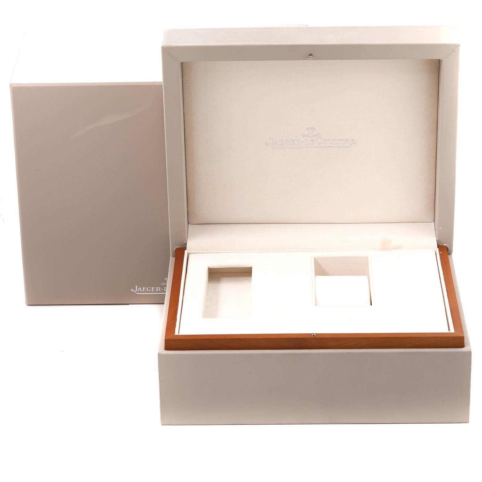 The image shows an open presentation box for a Jaeger-LeCoultre Reverso, displaying internal compartments with a branded lid.