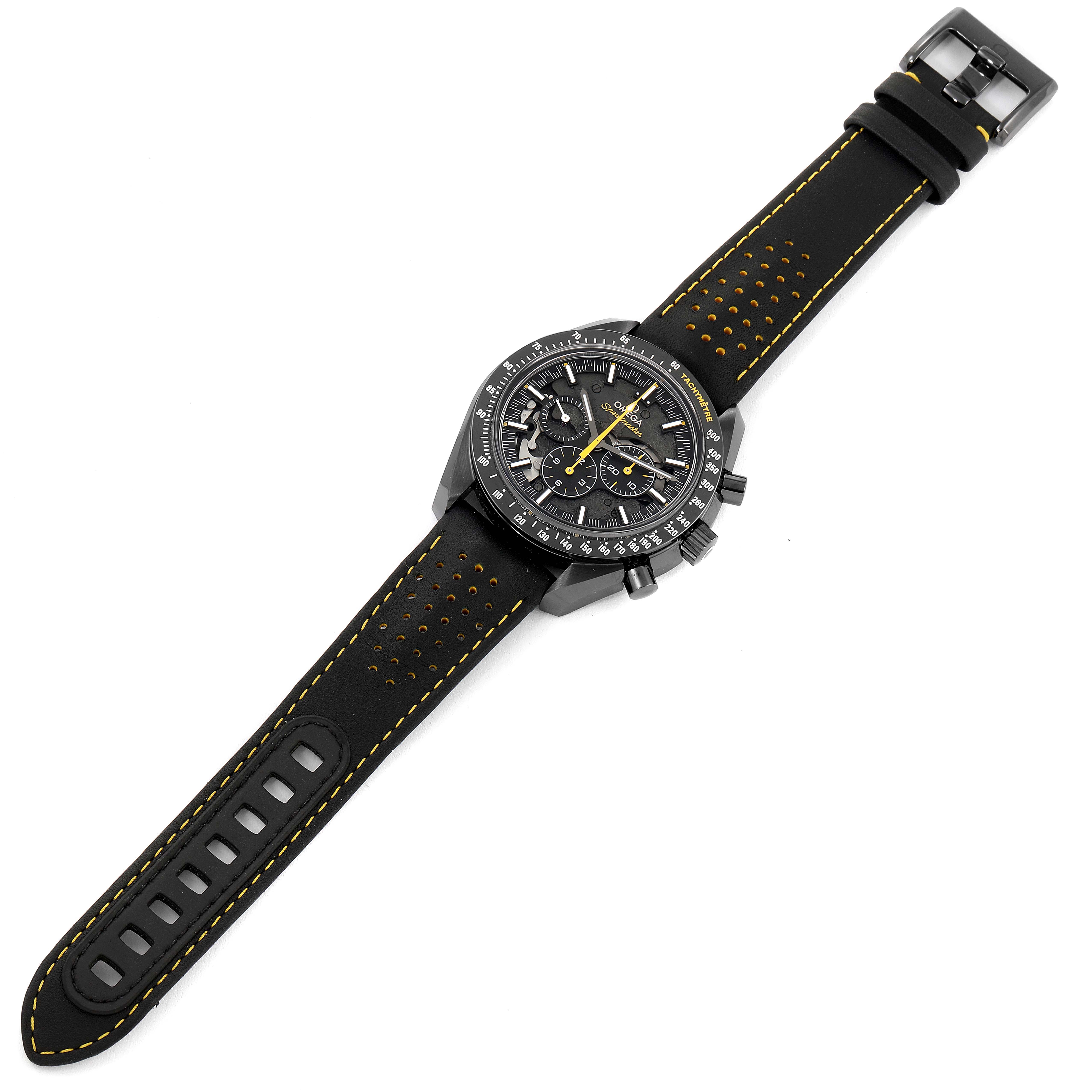 The image shows a top-down view of an Omega Speedmaster 311.92.44.30.01.001 Men's Ceramic Black Dial 311.92.44.30.01.001 Men's Ceramic Black Dial watch with a black strap and yellow stitching.