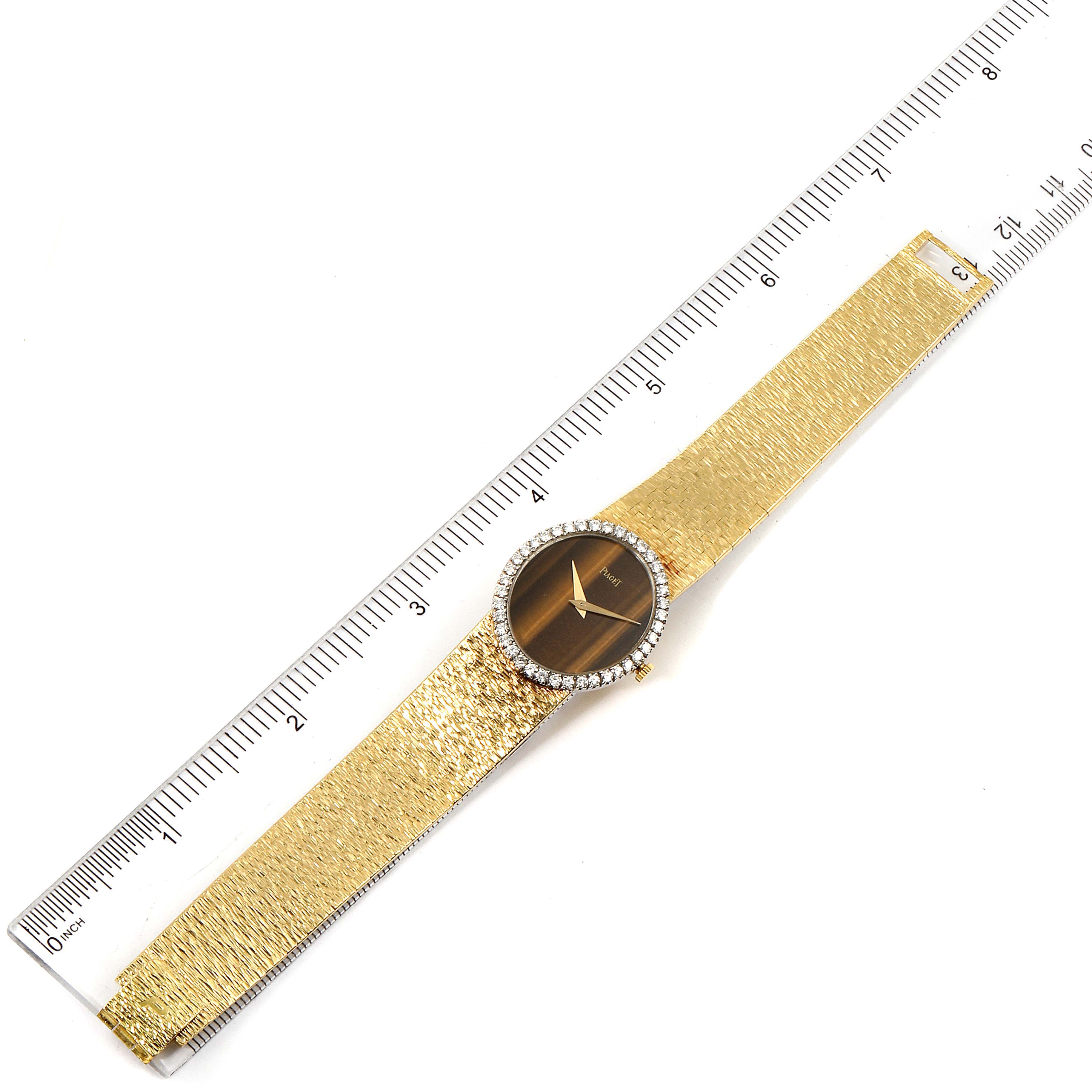 The image shows a top-down view of the Piaget 9826-A-6 Women's Yellow Gold Brown Dial 9826-A-6 Women's Yellow Gold Brown Dial 9826 Yellow Gold Diamond Tiger Eye Vintage Cocktail Ladies Watch next to a ruler for scale.