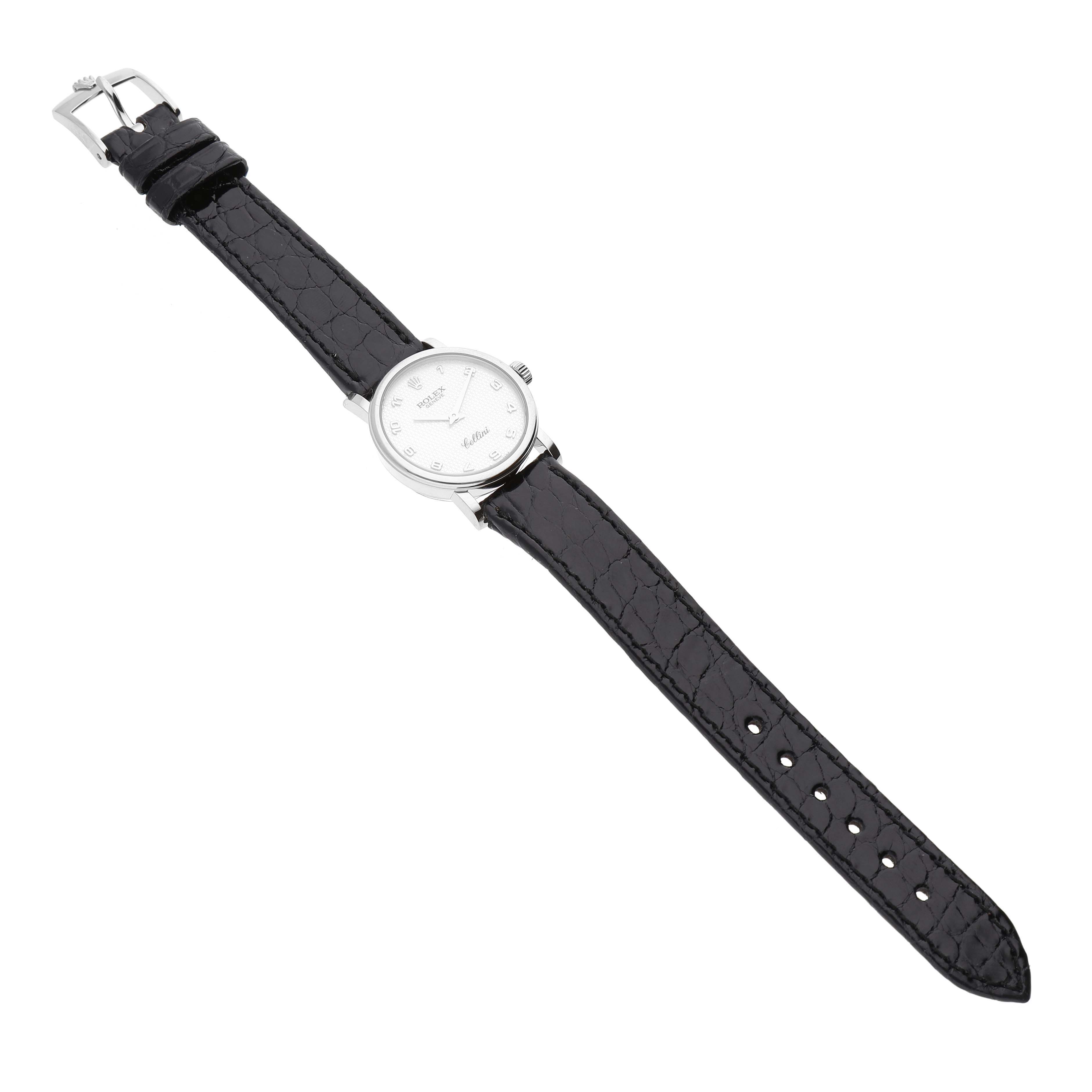 The Rolex Cellini 6110/9 Women's White Gold Mother of Pearl Dial 6110/9 Women's White Gold Mother of Pearl Dial watch is shown from an overhead angle, displaying the entire timepiece, including the face and black leather strap.