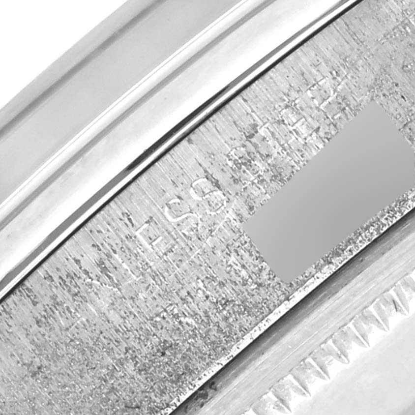 The image shows an angled close-up of the Rolex Date 1500 Men's Stainless Steel Blue Dial 1500 Men's Stainless Steel Blue Dial watch's rehaut with engraved details.