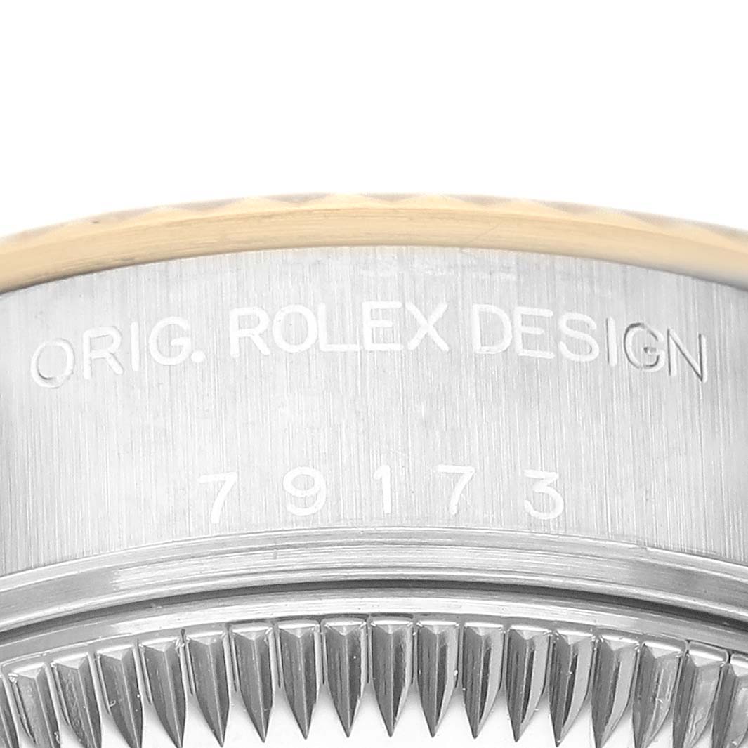 This image shows a close-up of the bezel and side case of a Rolex Datejust 79173 Women's Steel and Gold (two tone) Blue Dial 79173 Women's Steel and Gold (two tone) Blue Dial watch with the model number engraved.