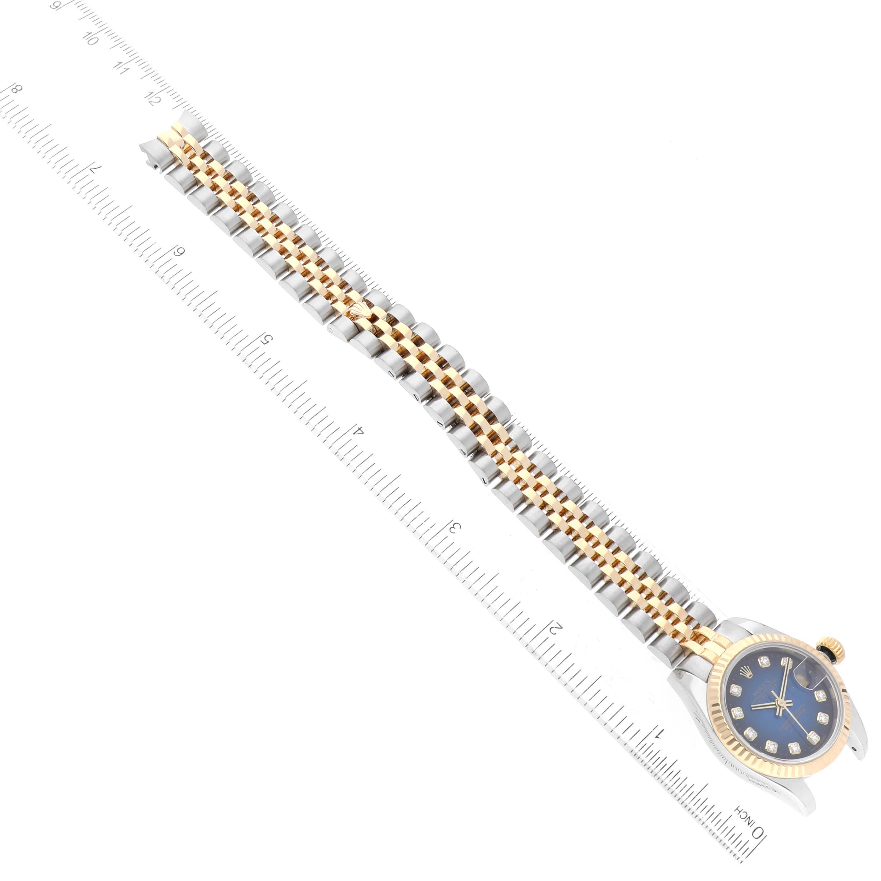 The image shows a Rolex Datejust 179173 Women's Steel and Gold (two tone) Blue Dial 179173 Women's Steel and Gold (two tone) Blue Dial watch from an overhead angle, including the watch face and full bracelet laid beside a ruler.