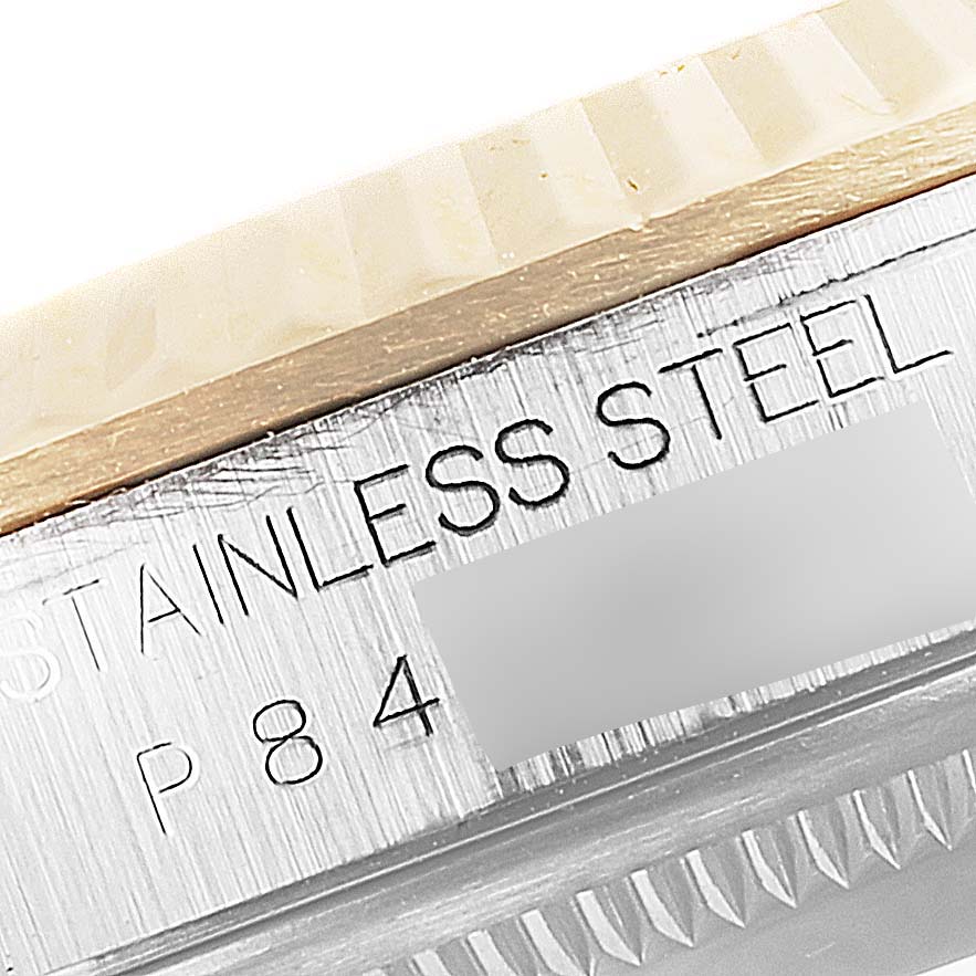 This close-up angle of a Rolex Datejust 16233 Men
s Steel and Gold (two tone) Grey Dial 16233 Men
s Steel and Gold (two tone) Grey Dial watch shows the bezel and part of the case with "STAINLESS STEEL" engraving.