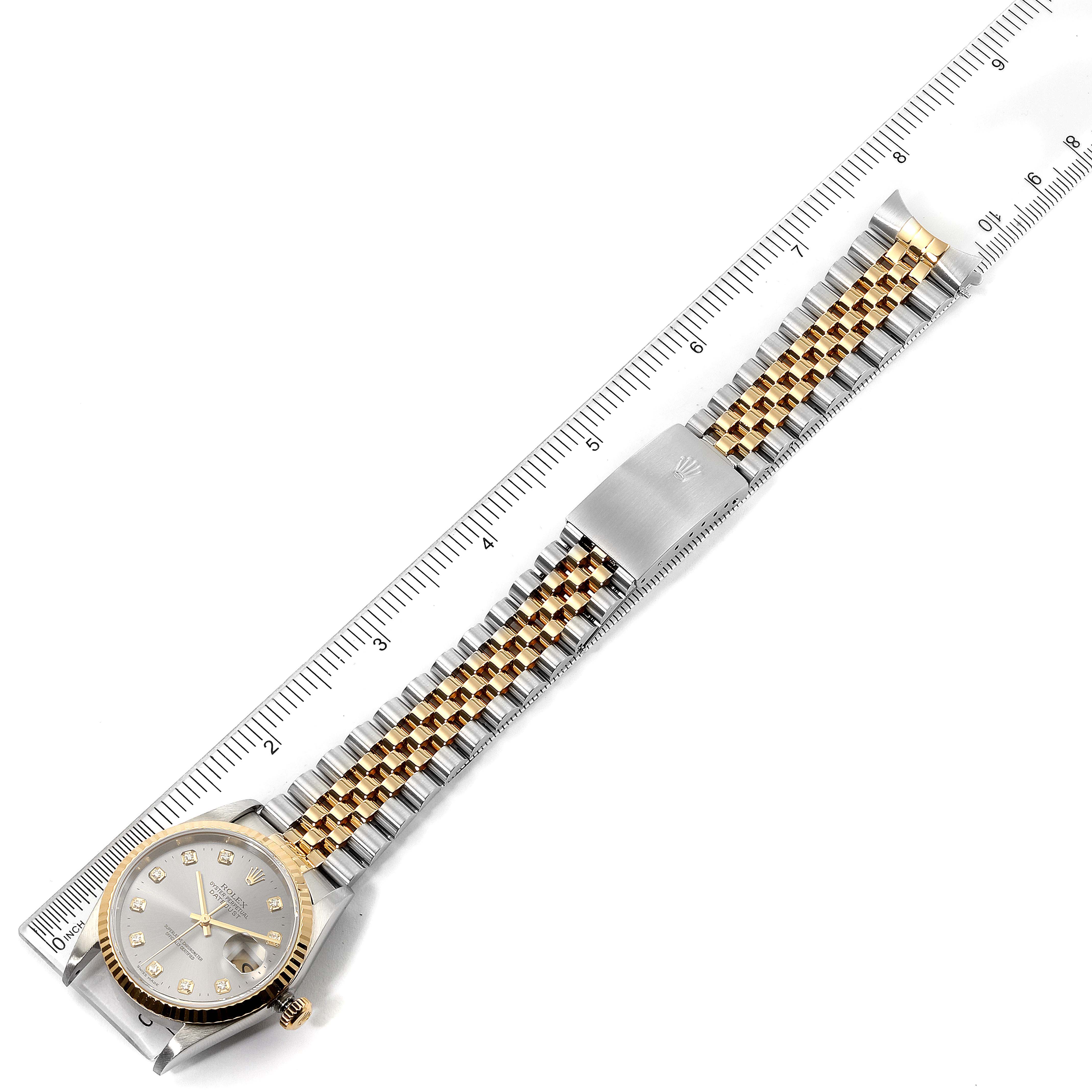 The image shows a top view of a Rolex Datejust 16233 Men
s Steel and Gold (two tone) Grey Dial 16233 Men
s Steel and Gold (two tone) Grey Dial watch, displaying the face, bezel, and metal bracelet against a ruler for scale.